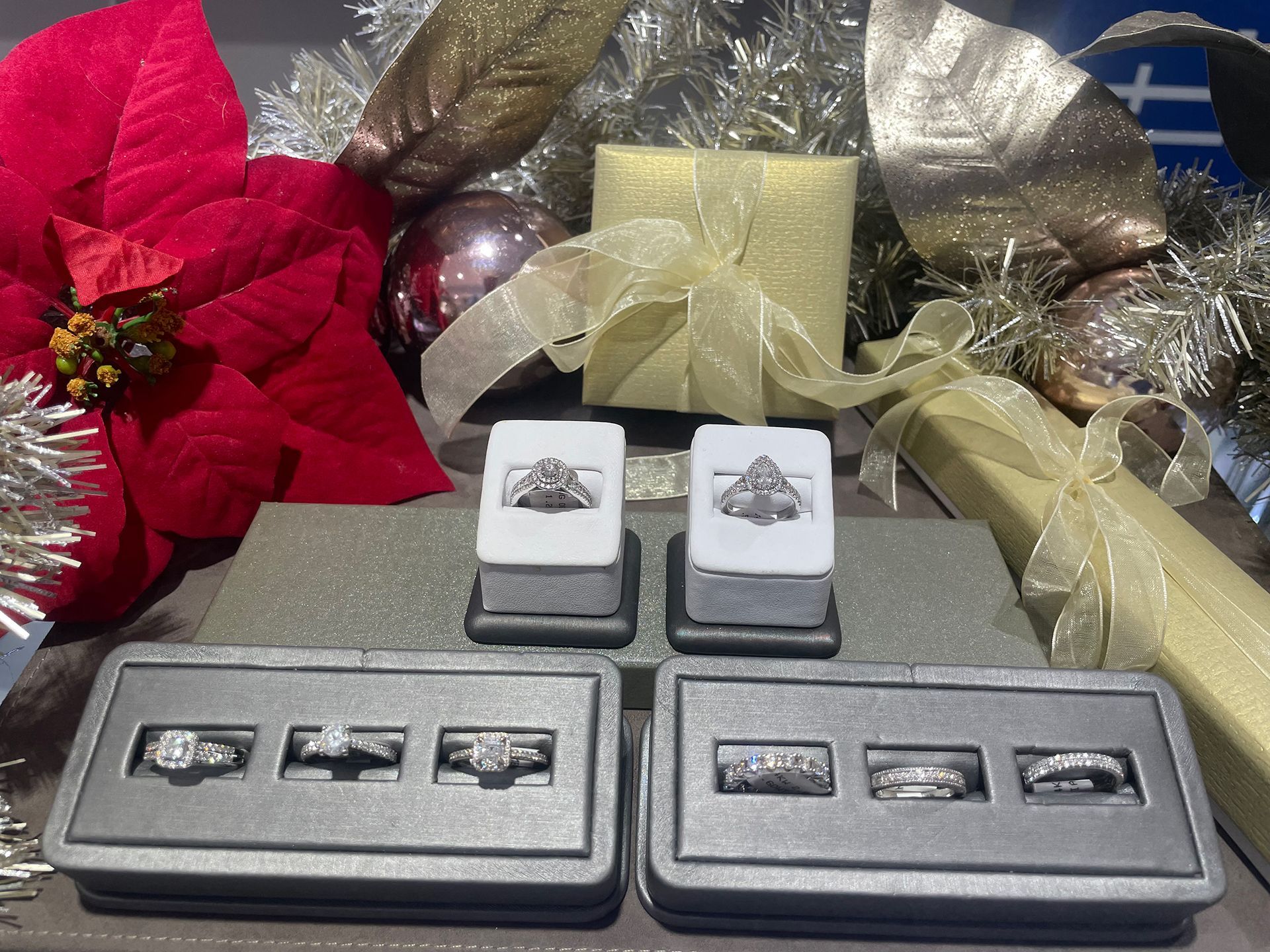 Jewelry display with engagement rings on stands, surrounded by festive Christmas decorations