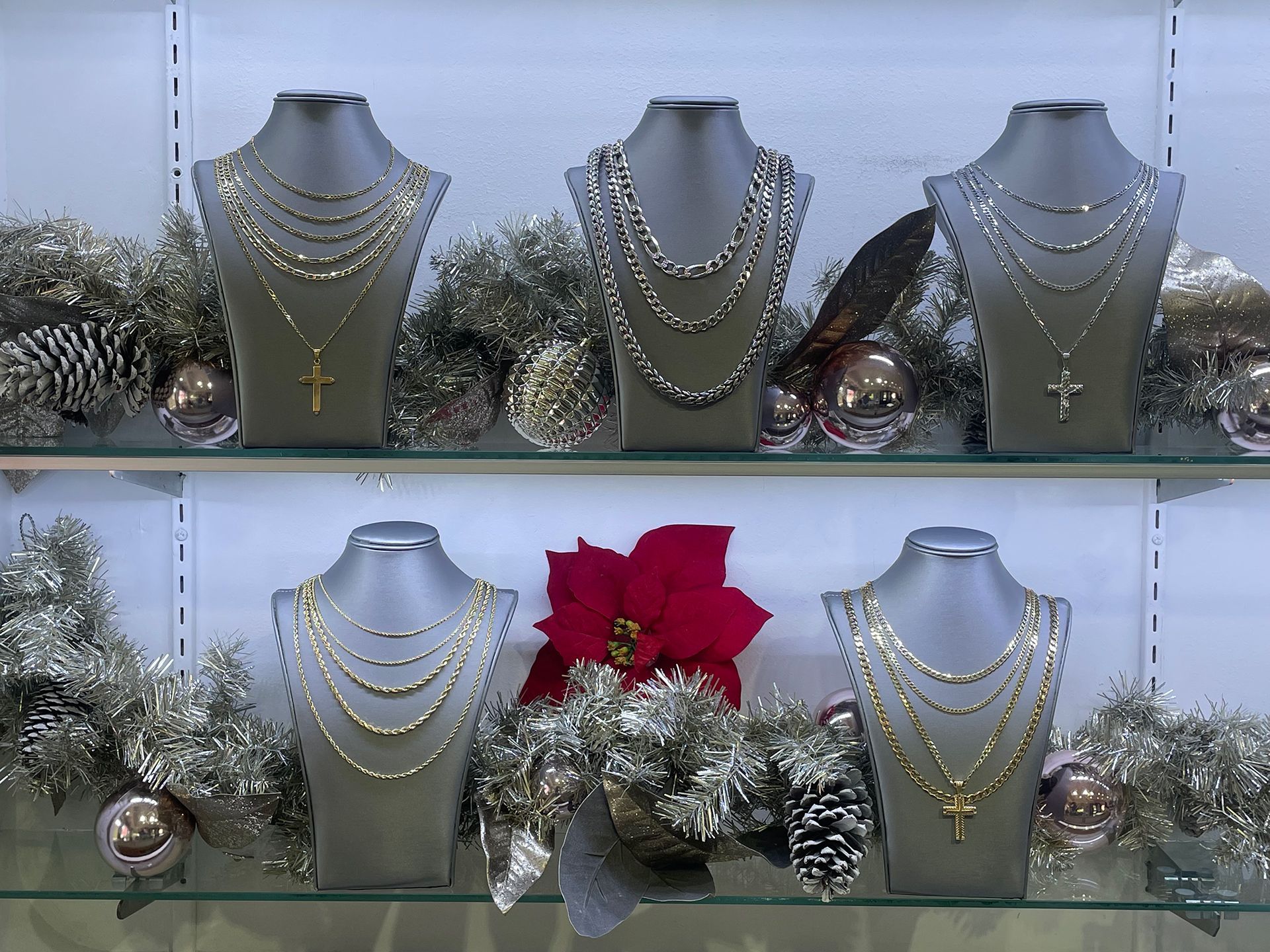 Necklaces displayed on mannequins in a jewelry store window