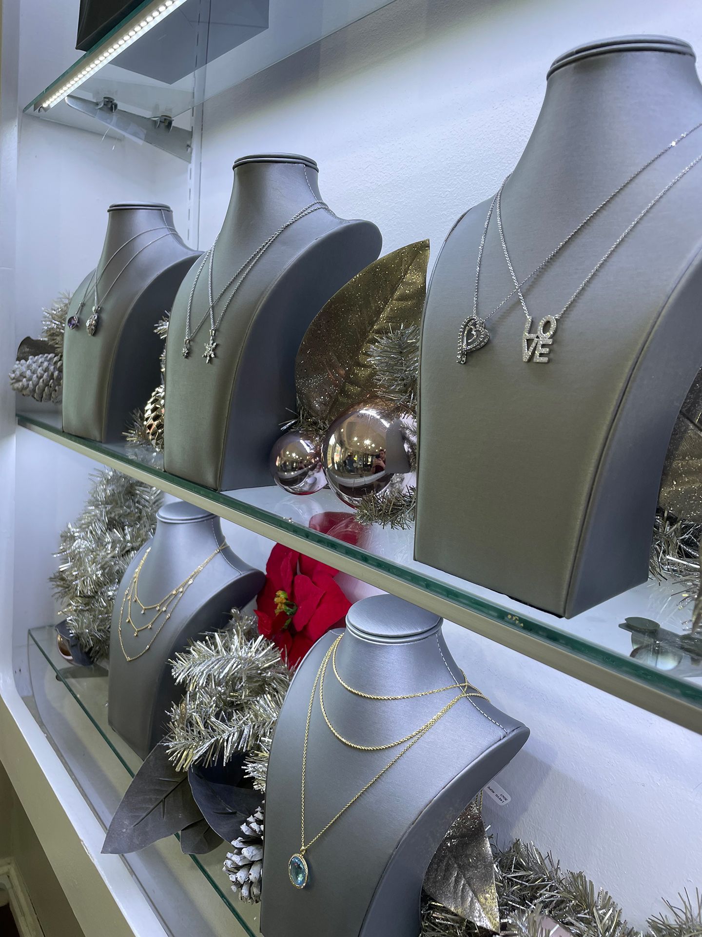 Necklaces displayed on mannequins in a jewelry store showcase