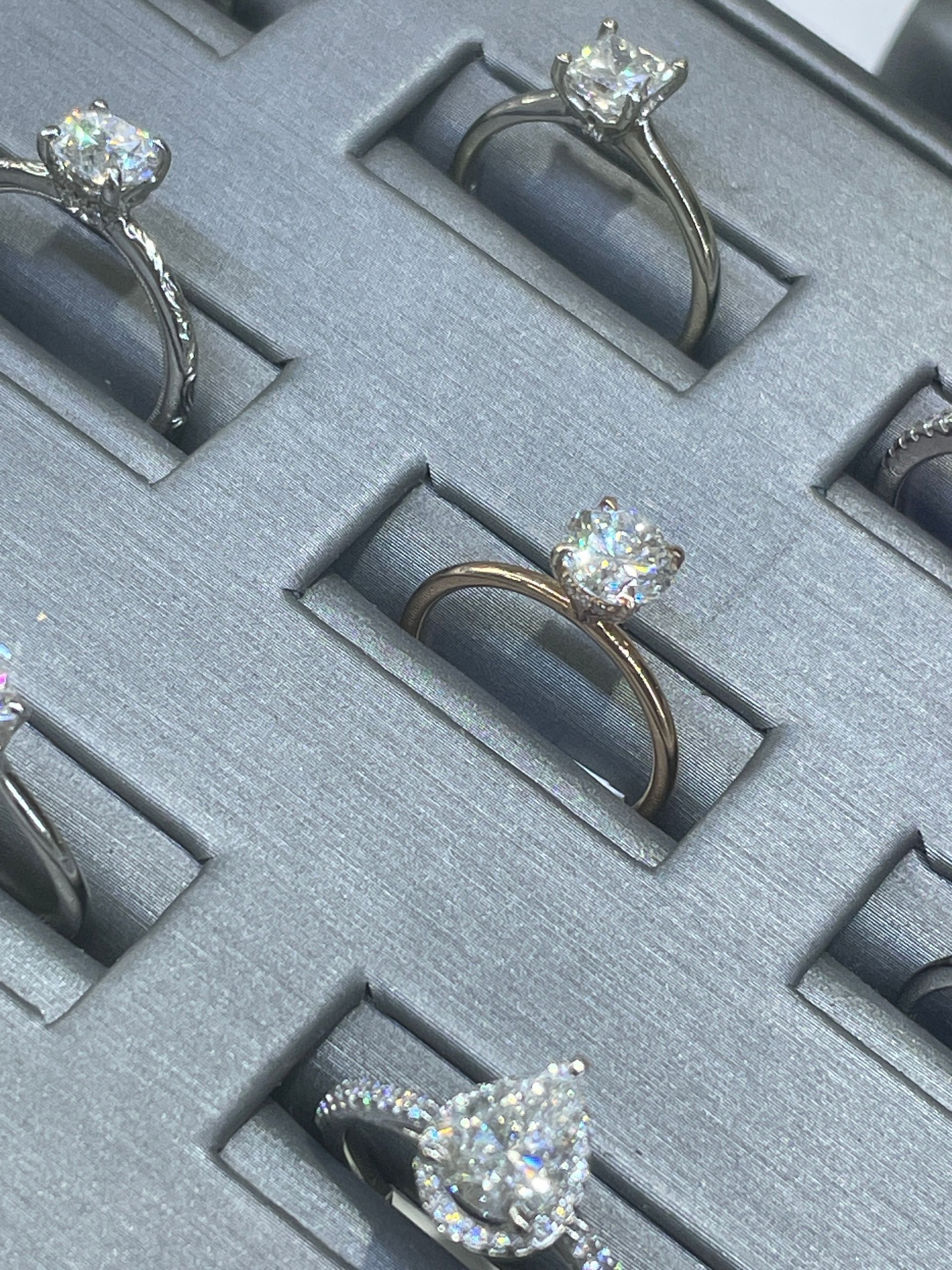 Diamond rings displayed in a gray jewelry tray