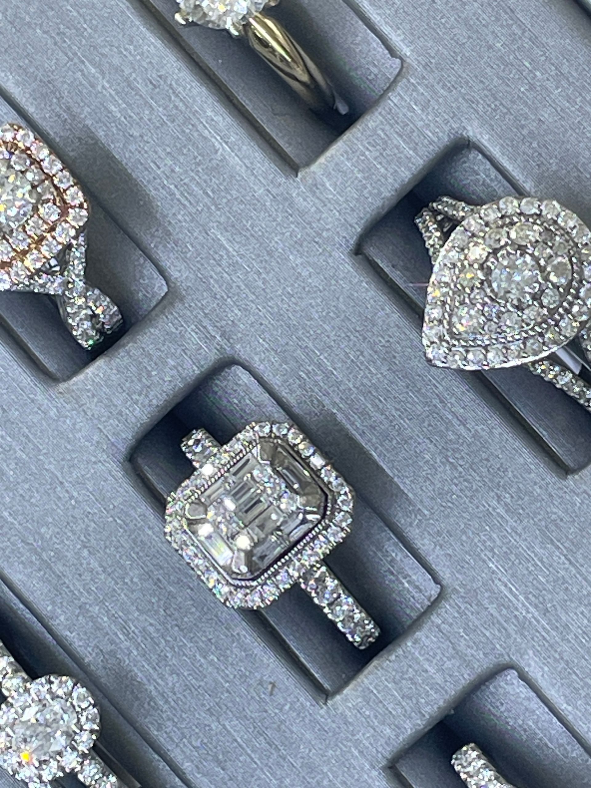 Diamond rings displayed in a gray velvet jewelry box