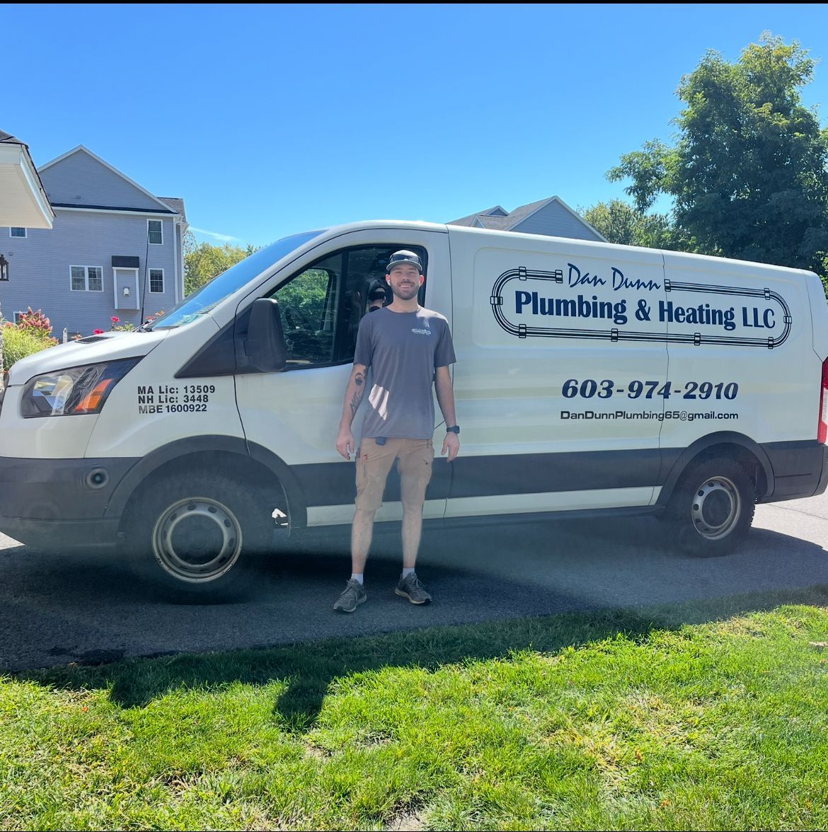 Man standing beside a white plumbing van, 