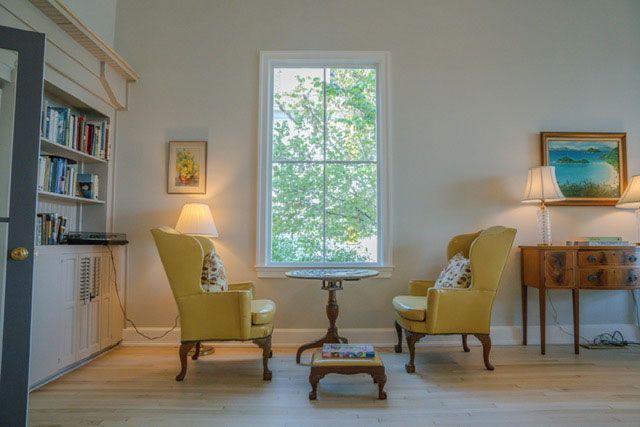 Bright living room with two yellow chairs facing a window and a small table between them