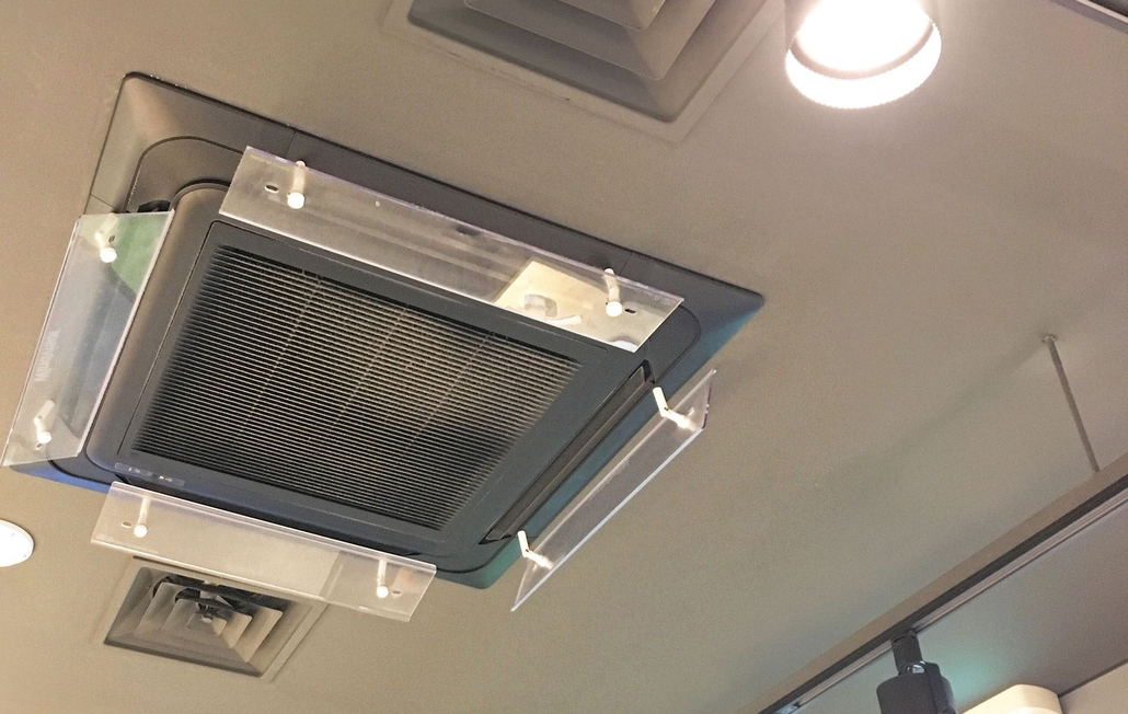Air vent on a ceiling with clear plastic guards.