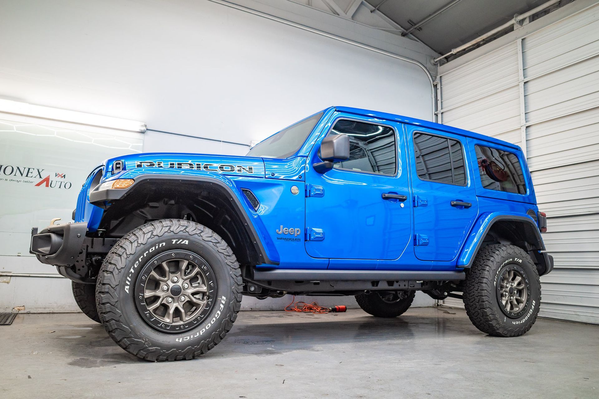 Blue Jeep Wrangler Rubicon SUV parked inside a garage.