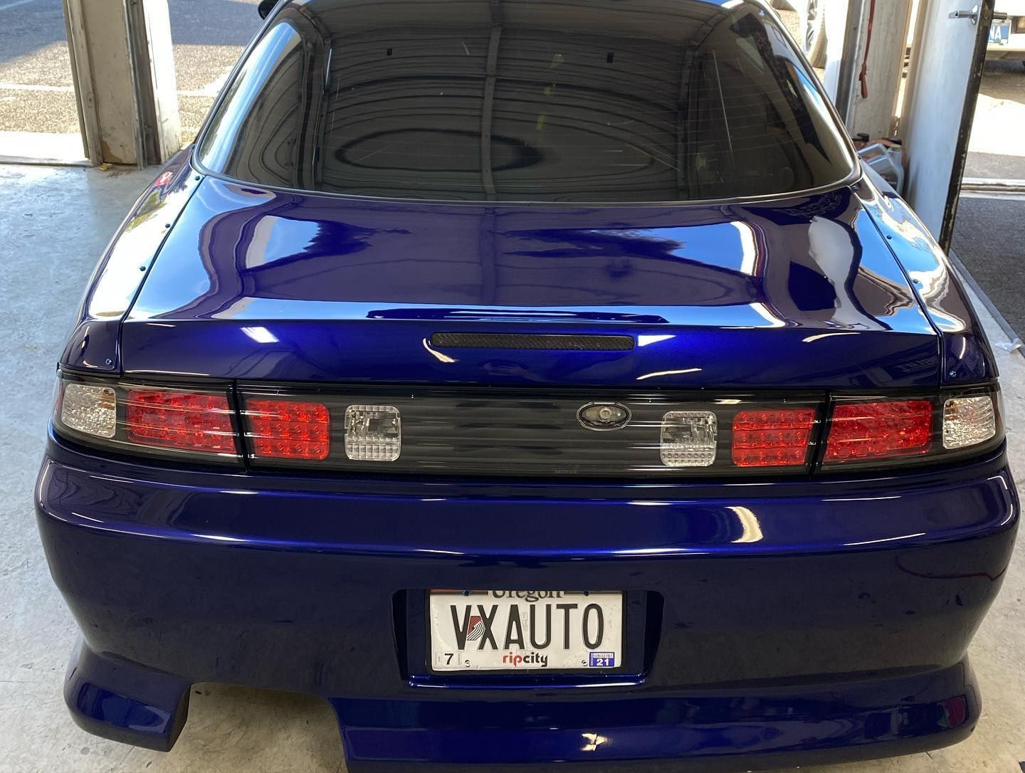 Rear view of a dark blue Nissan 240SX car with a 
