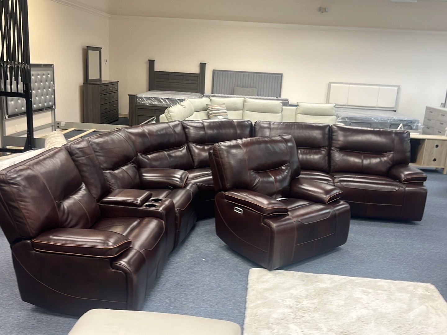 Dark brown leather sectional sofa and matching ottoman in a furniture showroom