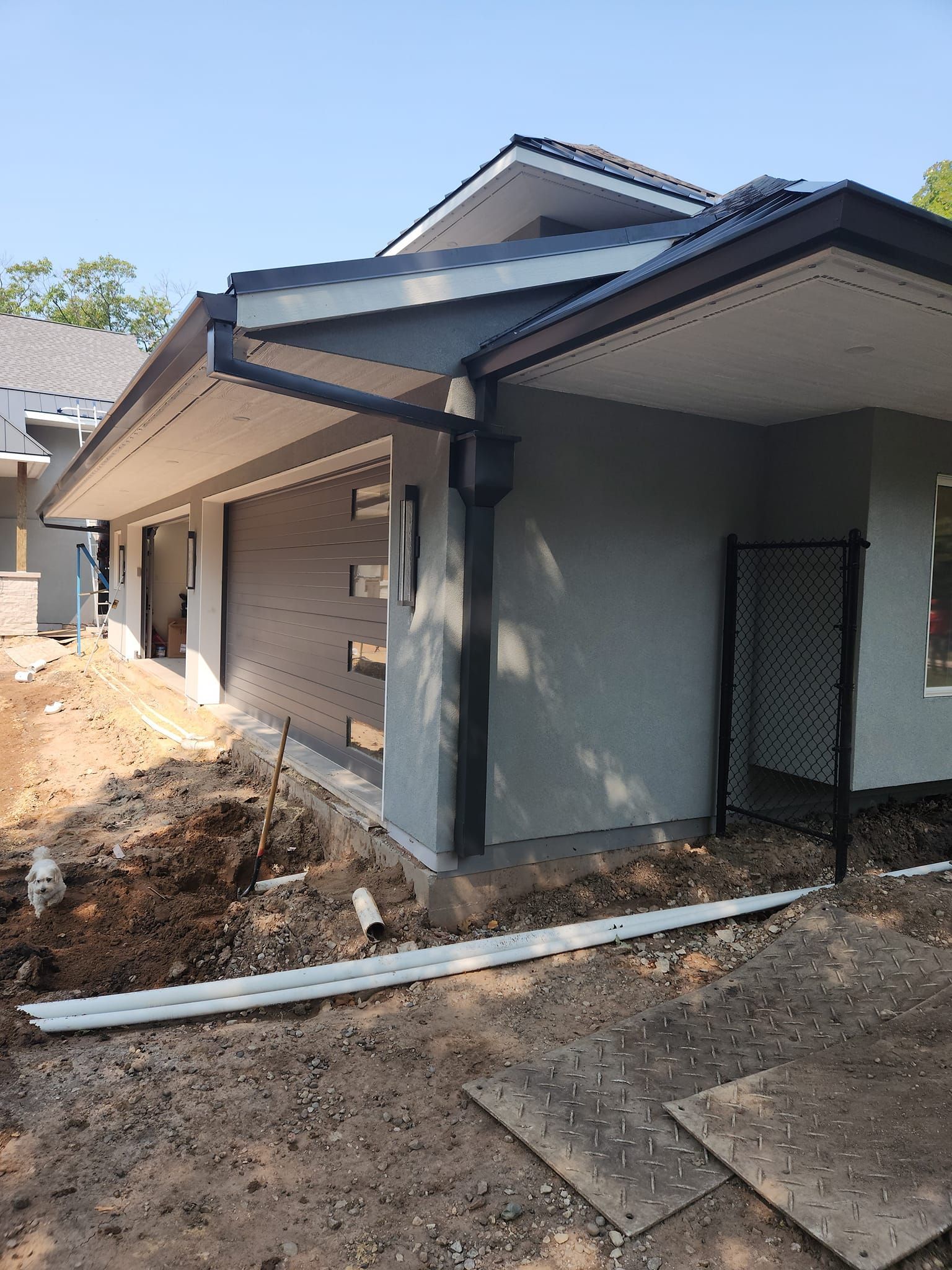 A house is being built with a chain link fence in front of it.