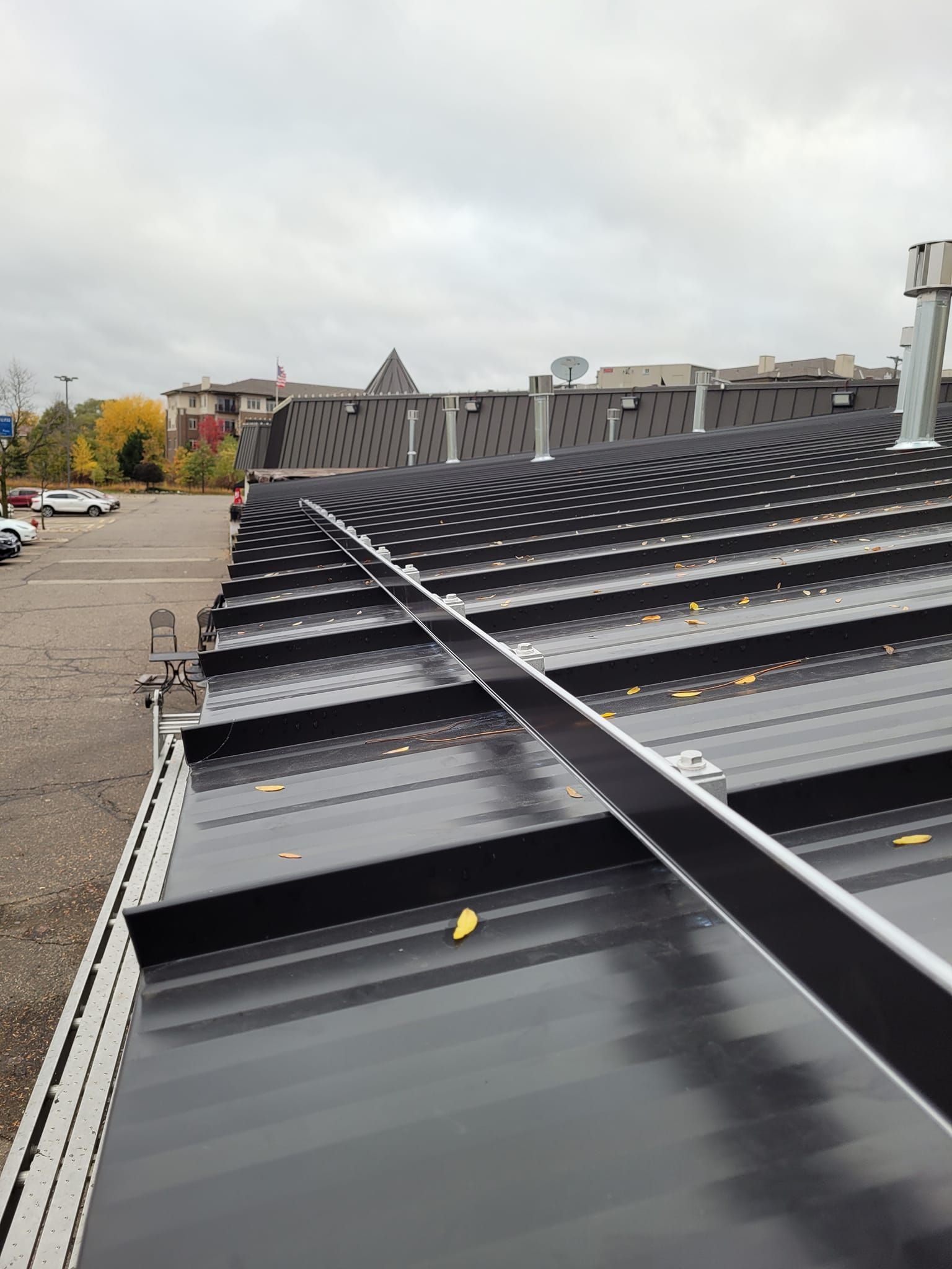 A black roof with a metal railing attached to it