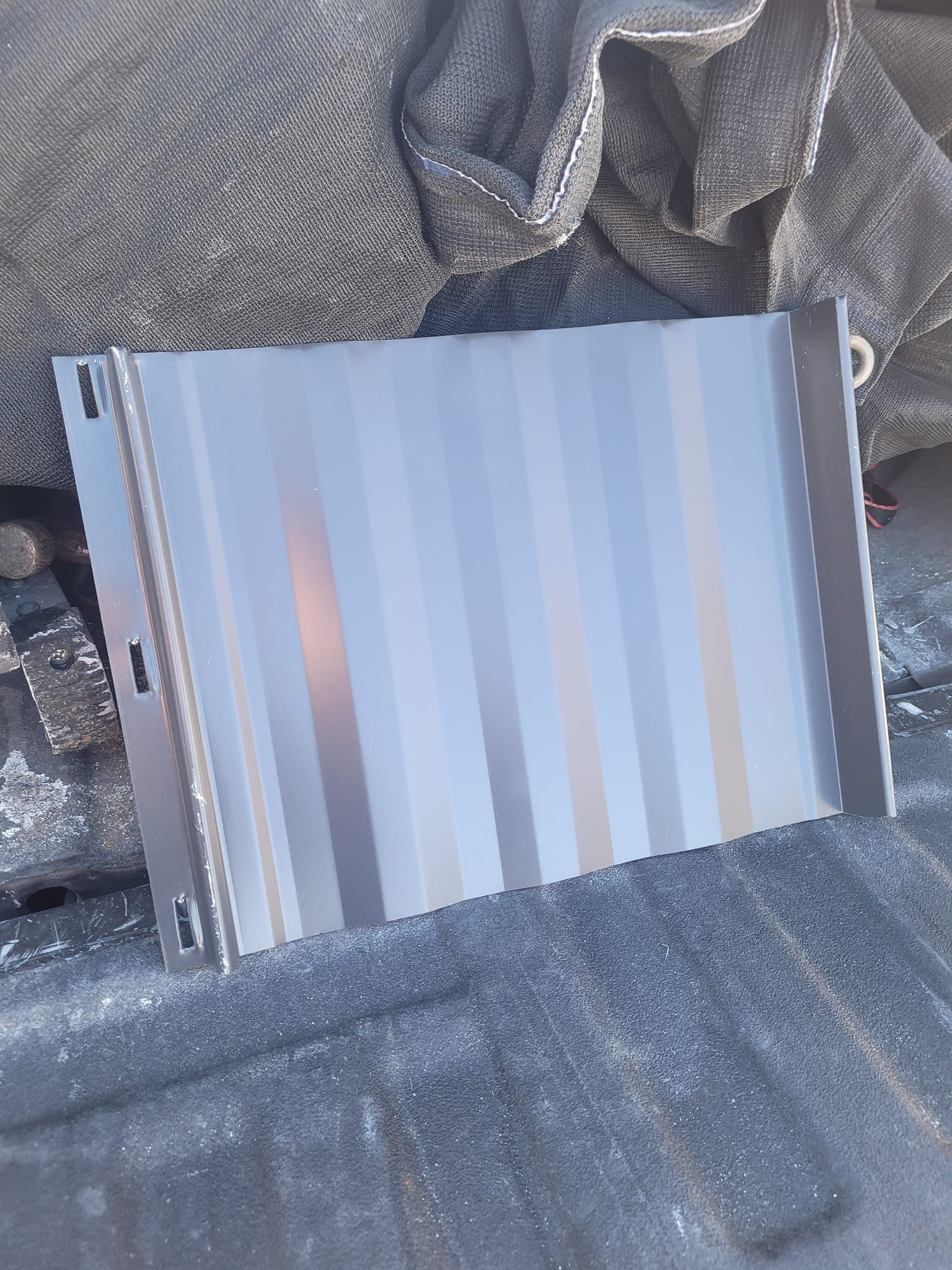 A piece of metal is sitting on top of a pile of rocks.