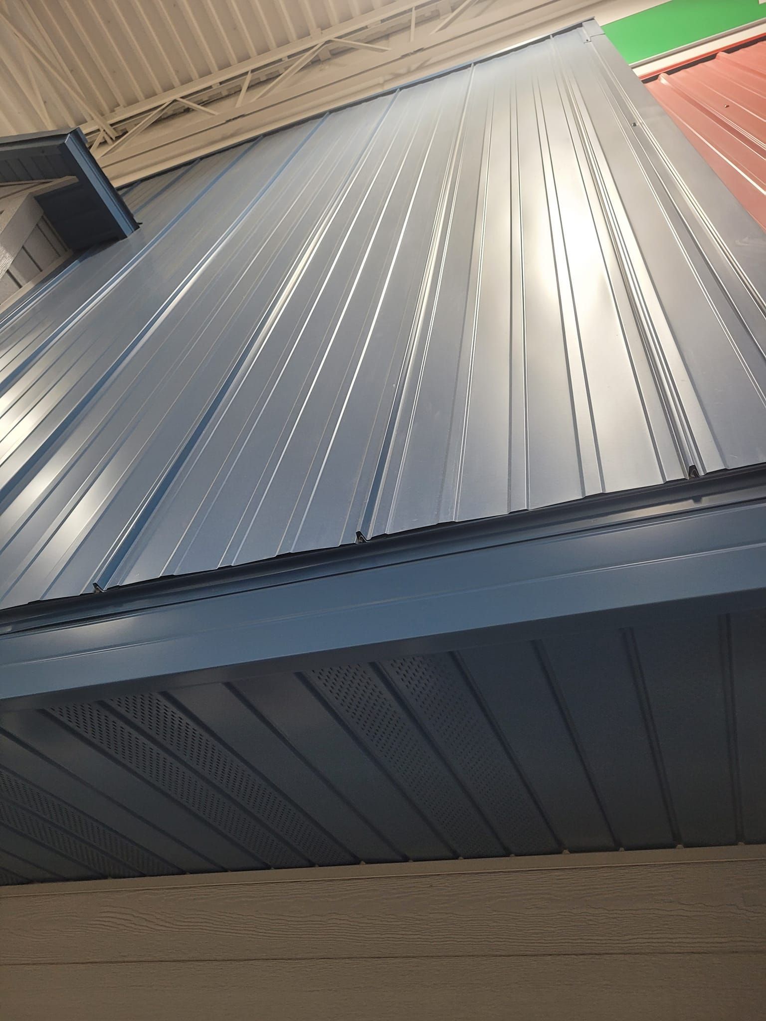 Looking up at a blue metal roof in a building