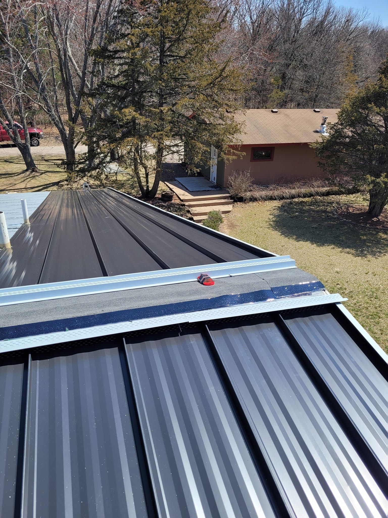 A metal roof is being installed on top of a house.