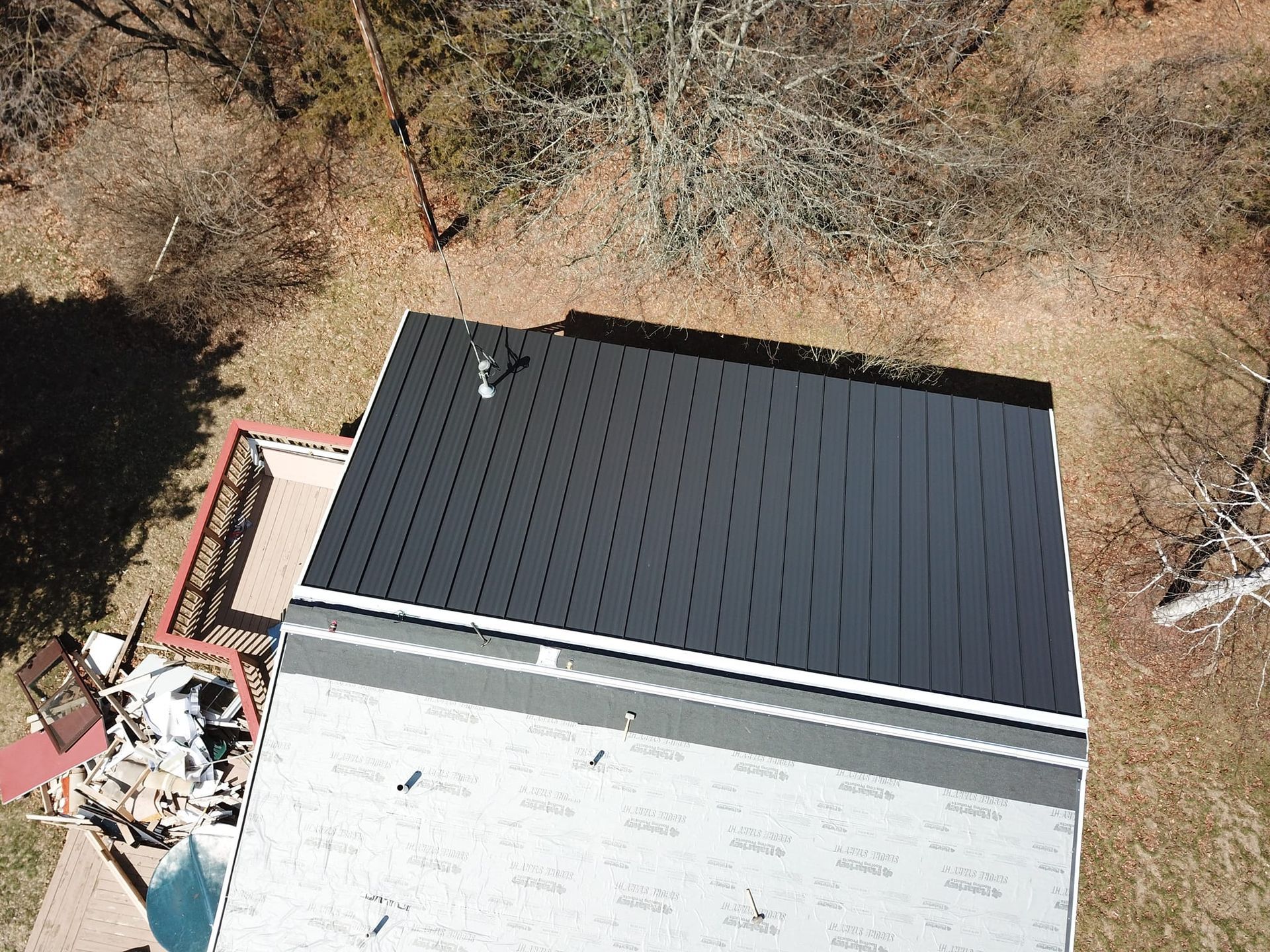 An aerial view of a house with a solar panel on the roof.