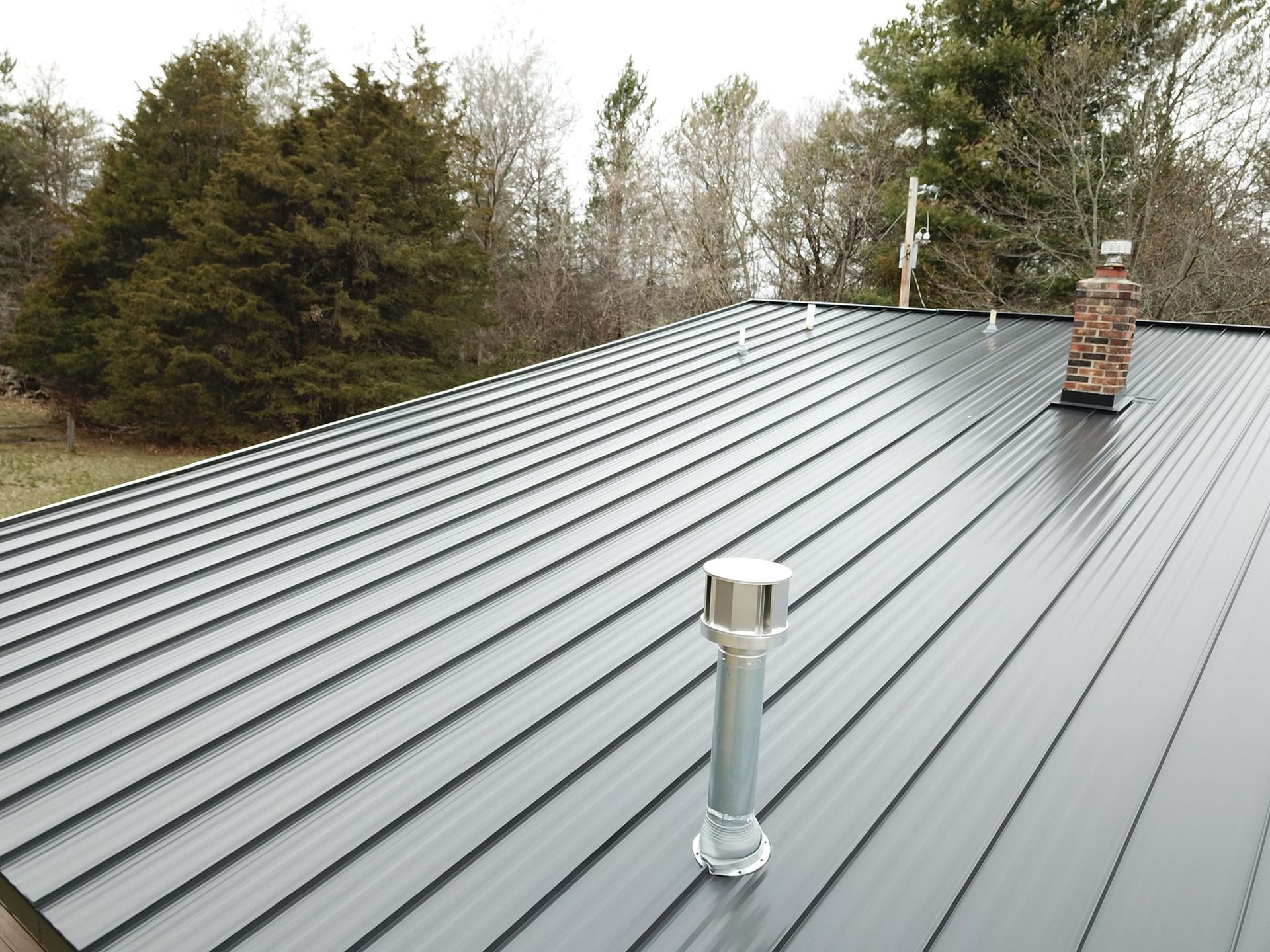 A black roof with a chimney on top of it
