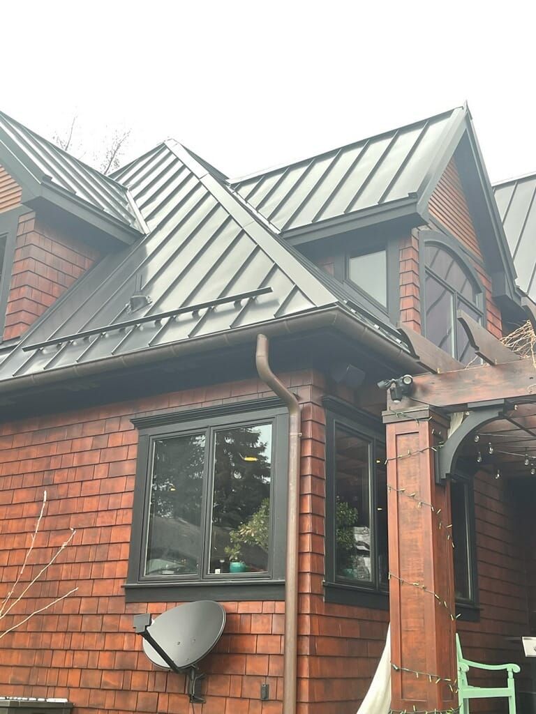 A brick house with a metal roof and windows