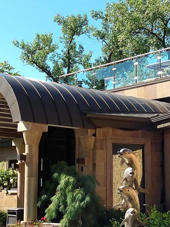 A building with a balcony and a statue of dolphins on the side