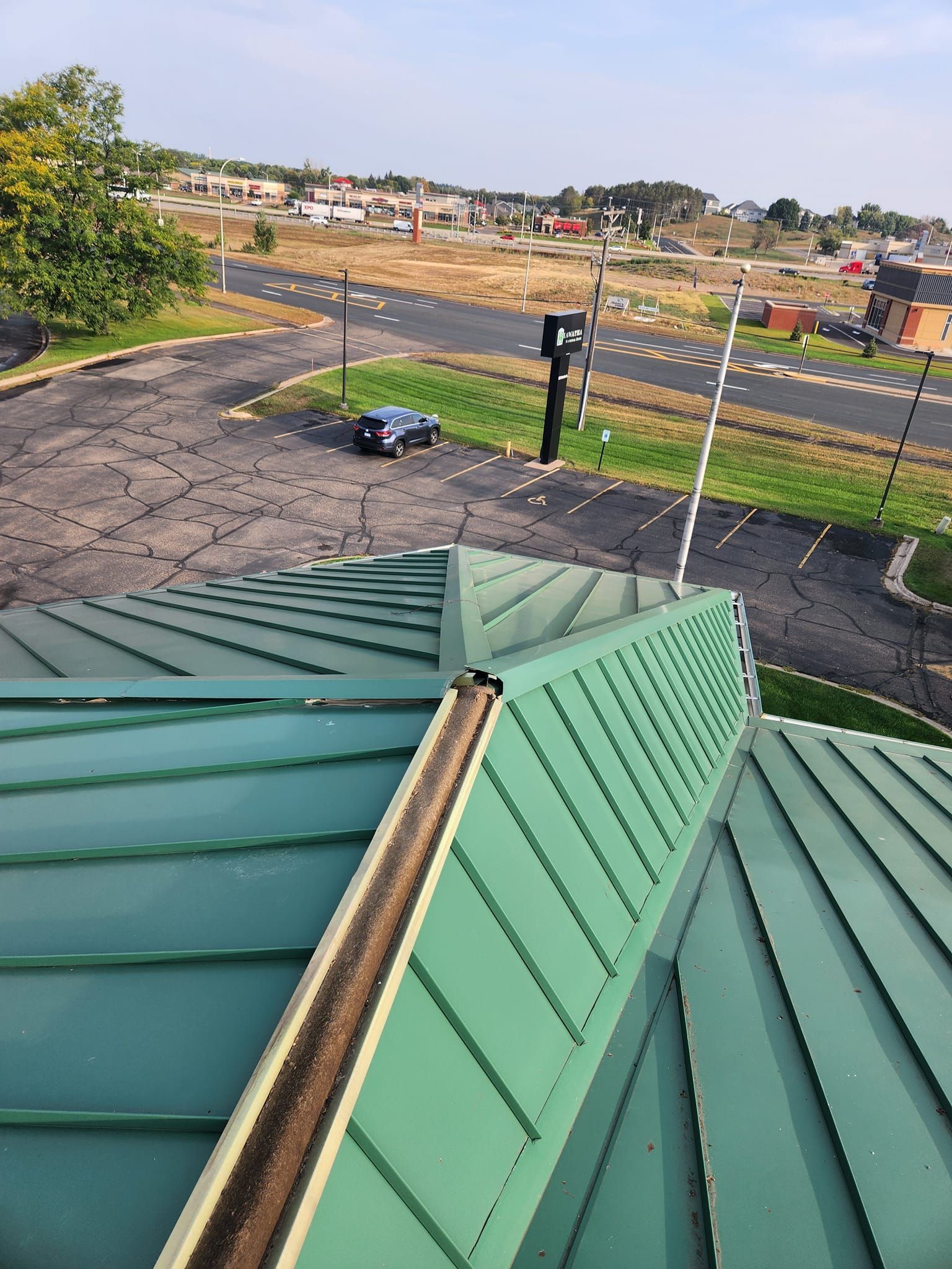 A green roof with a car parked on the side of it.
