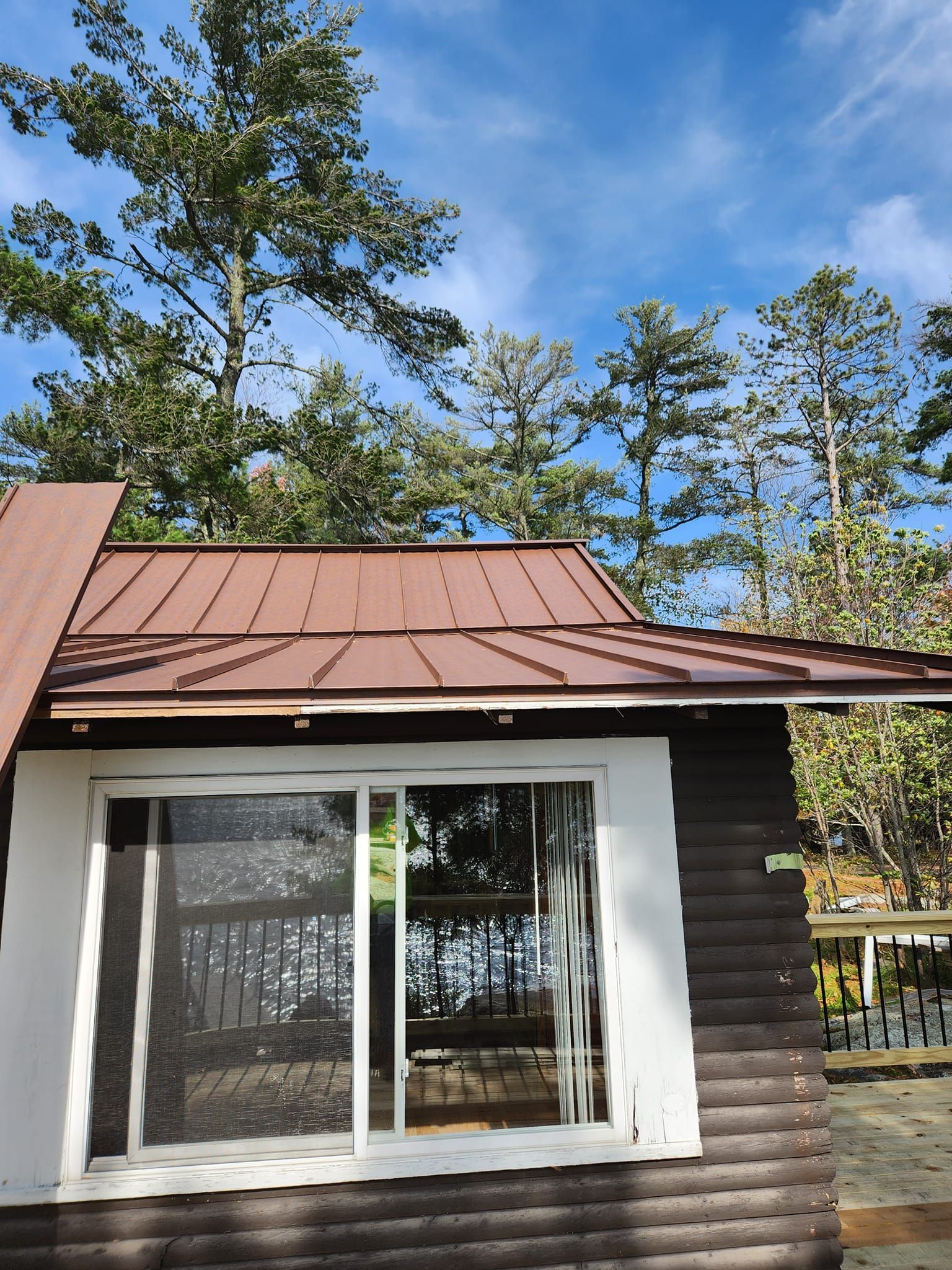 A small house with a brown roof and a sliding glass door
