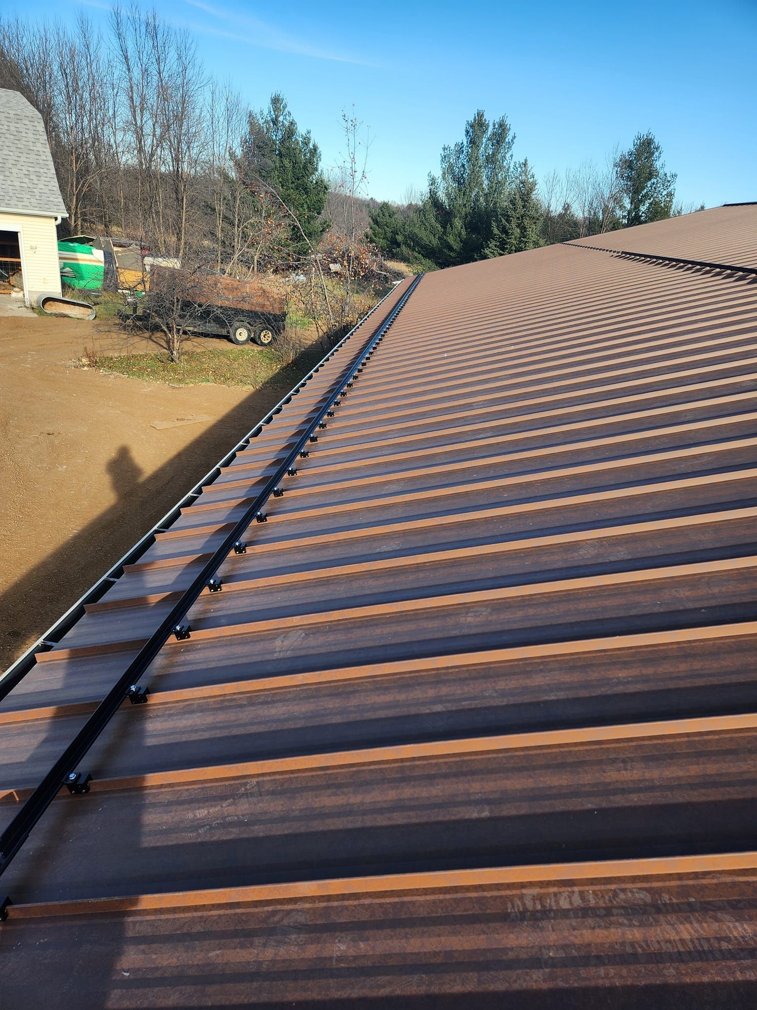 A close up of a roof with trees in the background.