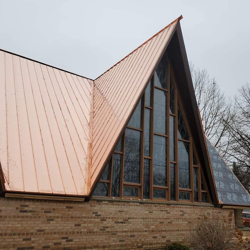 A church with a copper roof and stained glass windows