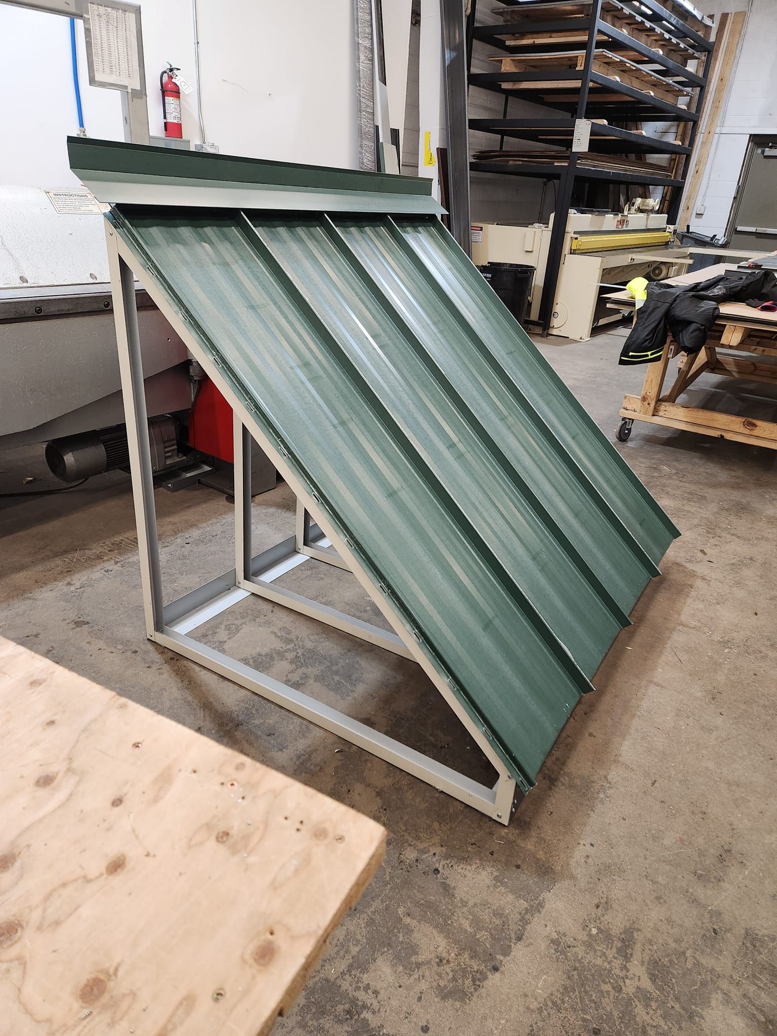 A green metal roof is sitting on top of a wooden table.