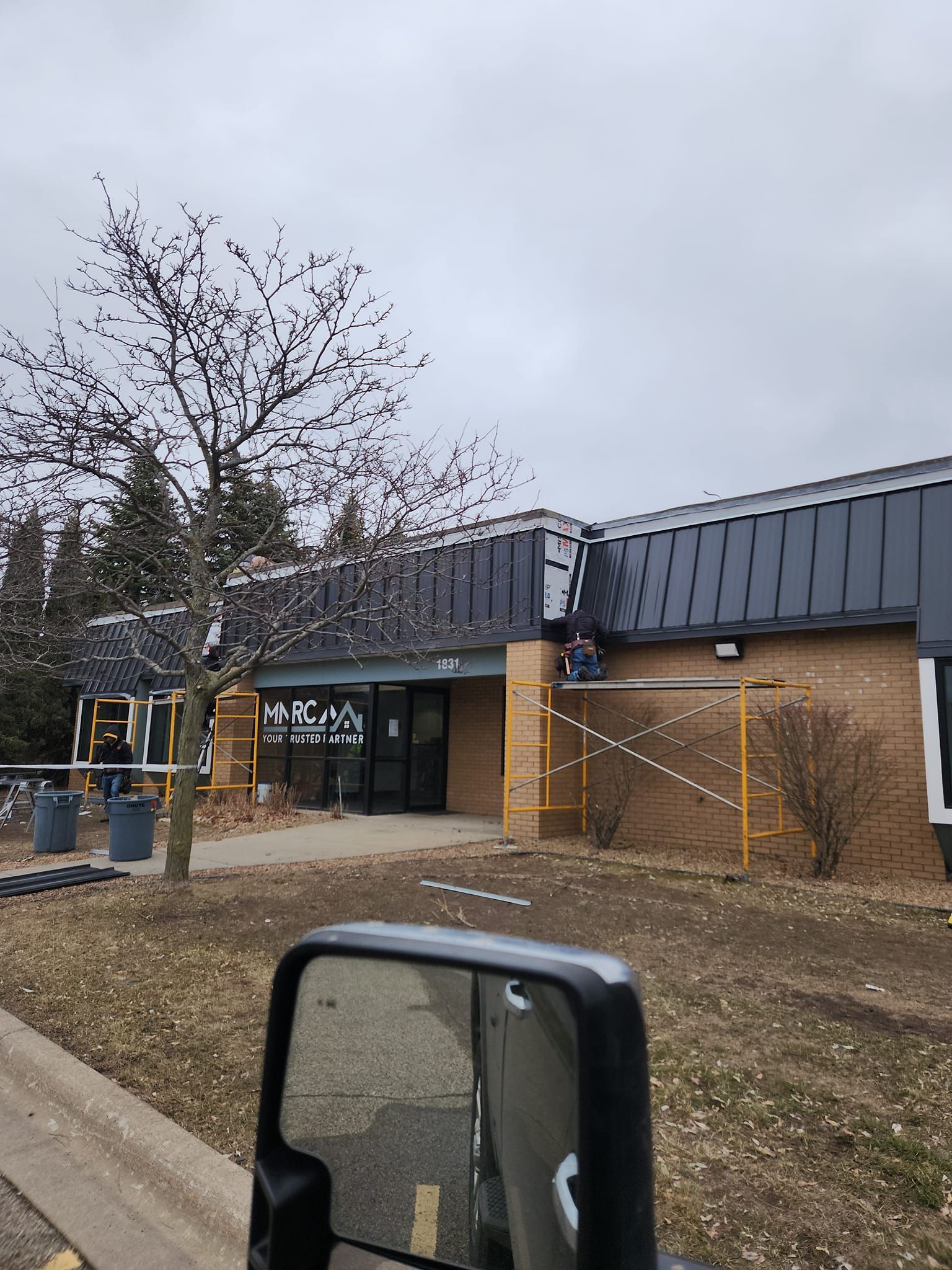 A truck is parked in front of a building under construction.