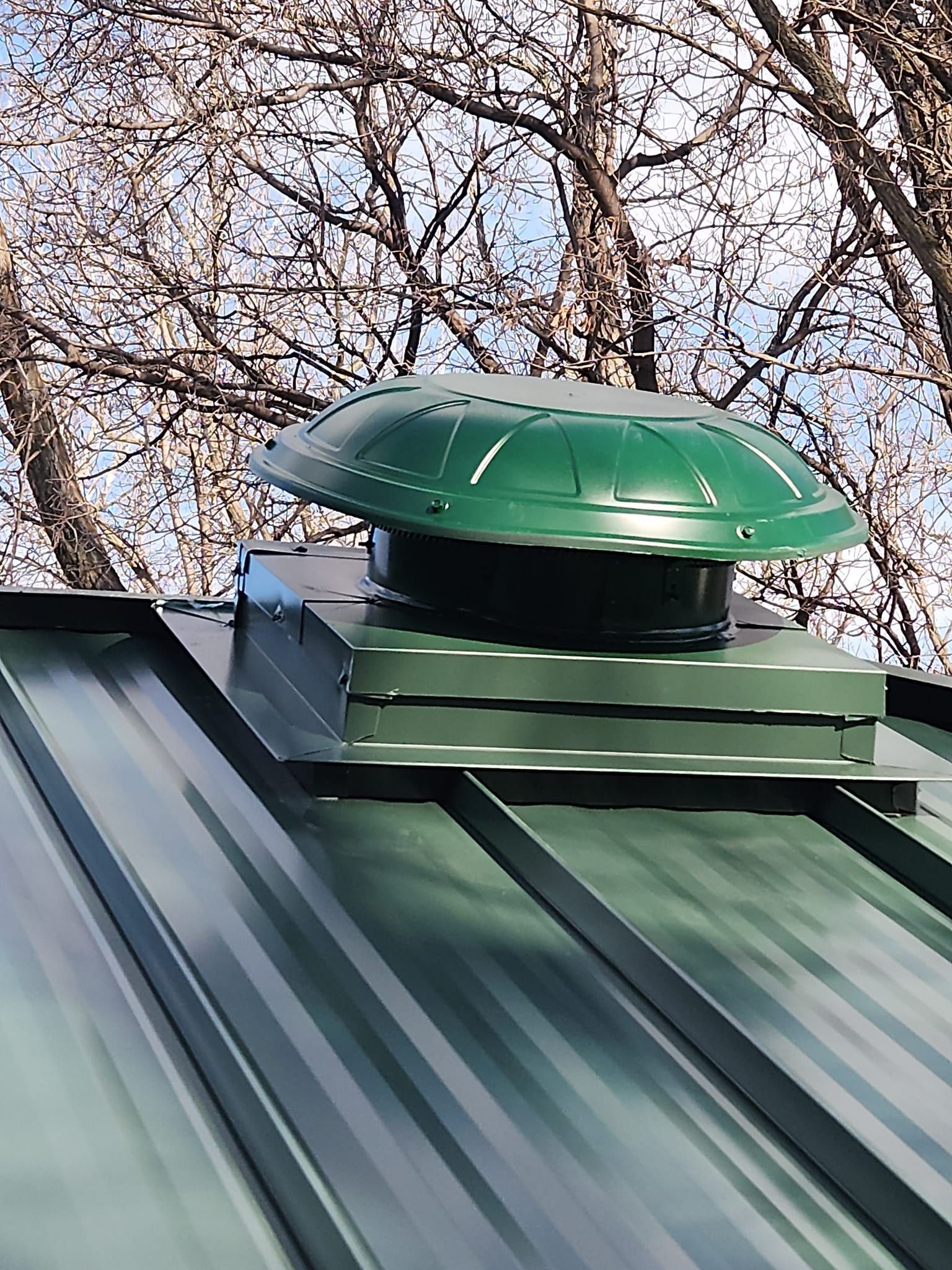 A green roof with a fan on top of it.
