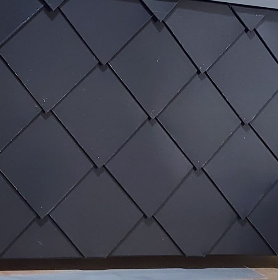 A close up of a black roof with a diamond pattern.