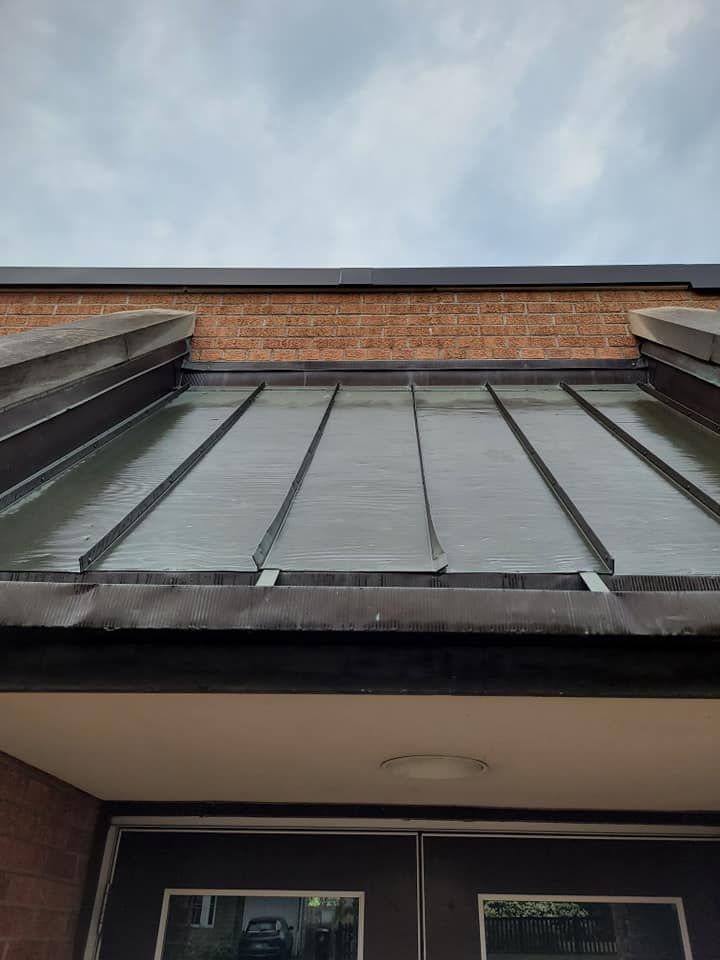 The roof of a building with a glass roof and a brick wall.
