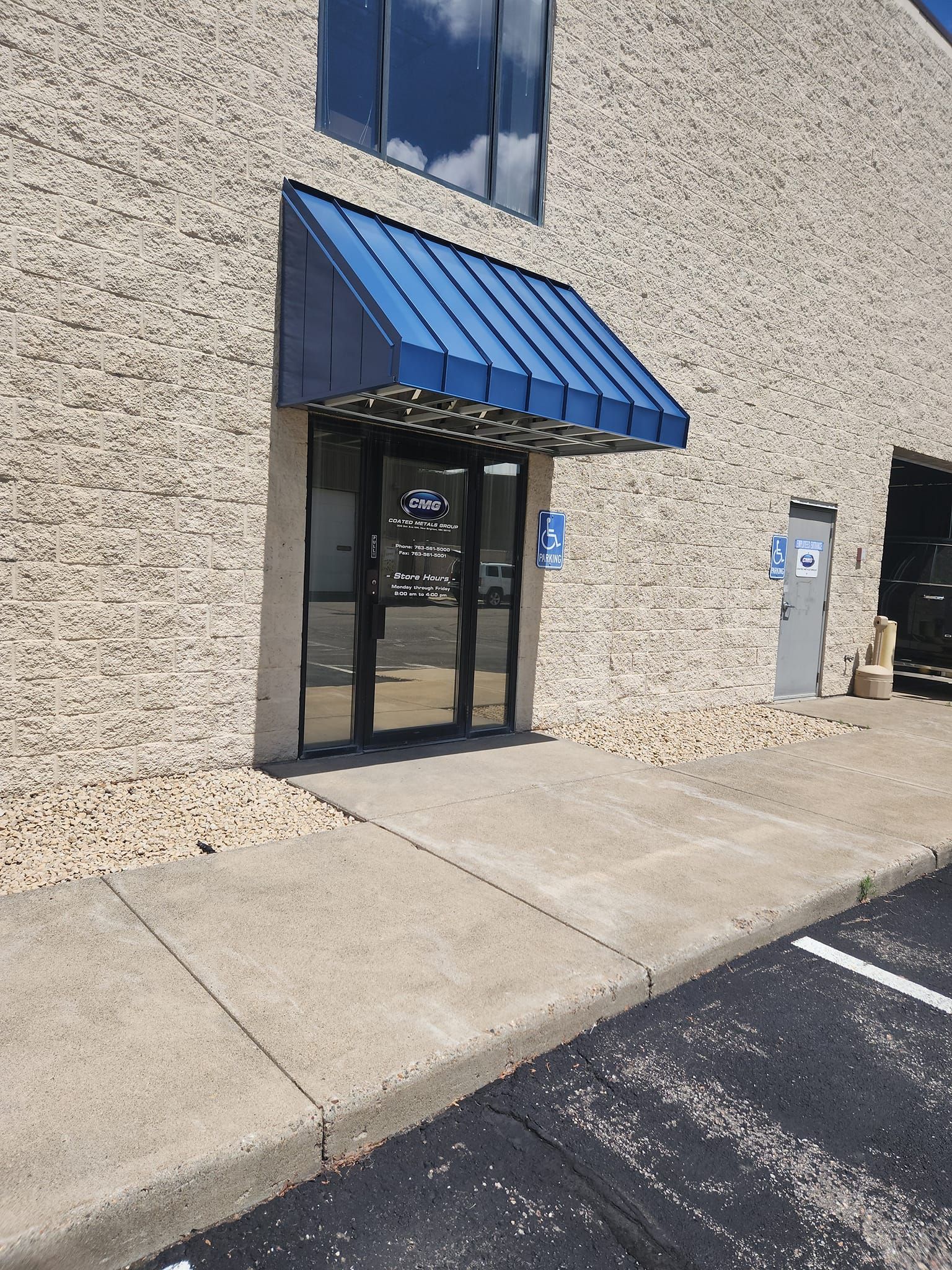A brick building with a blue awning over the door.