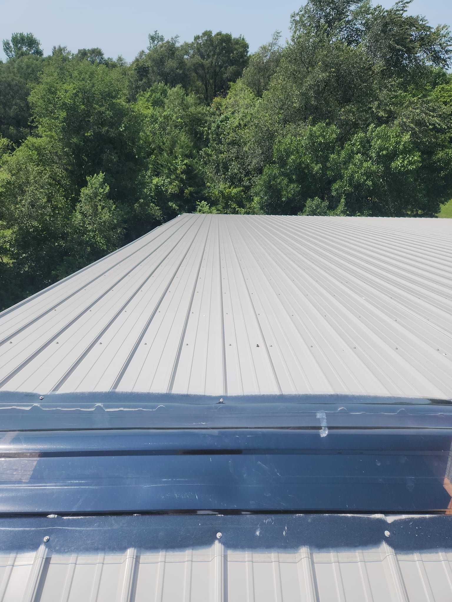 The roof of a building with trees in the background