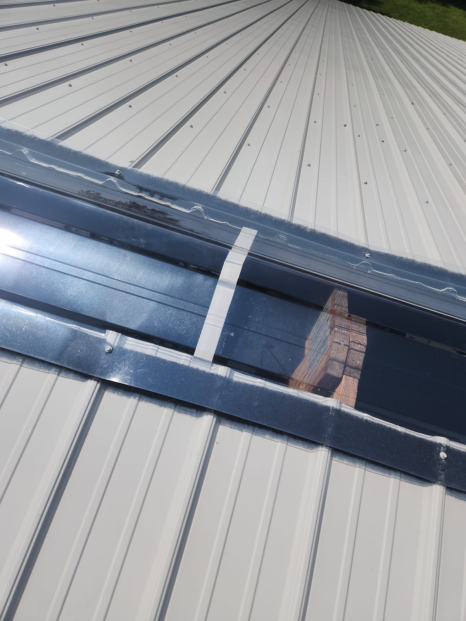 A close up of a roof with a reflection of a person on it