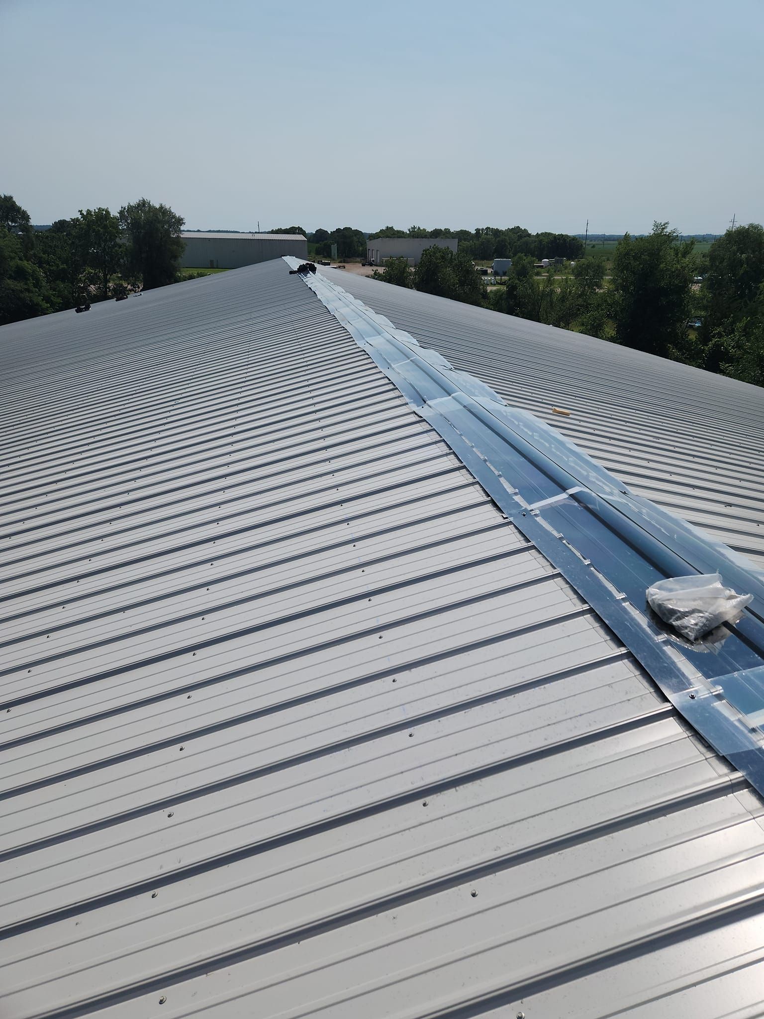 An aerial view of a roof with trees in the background