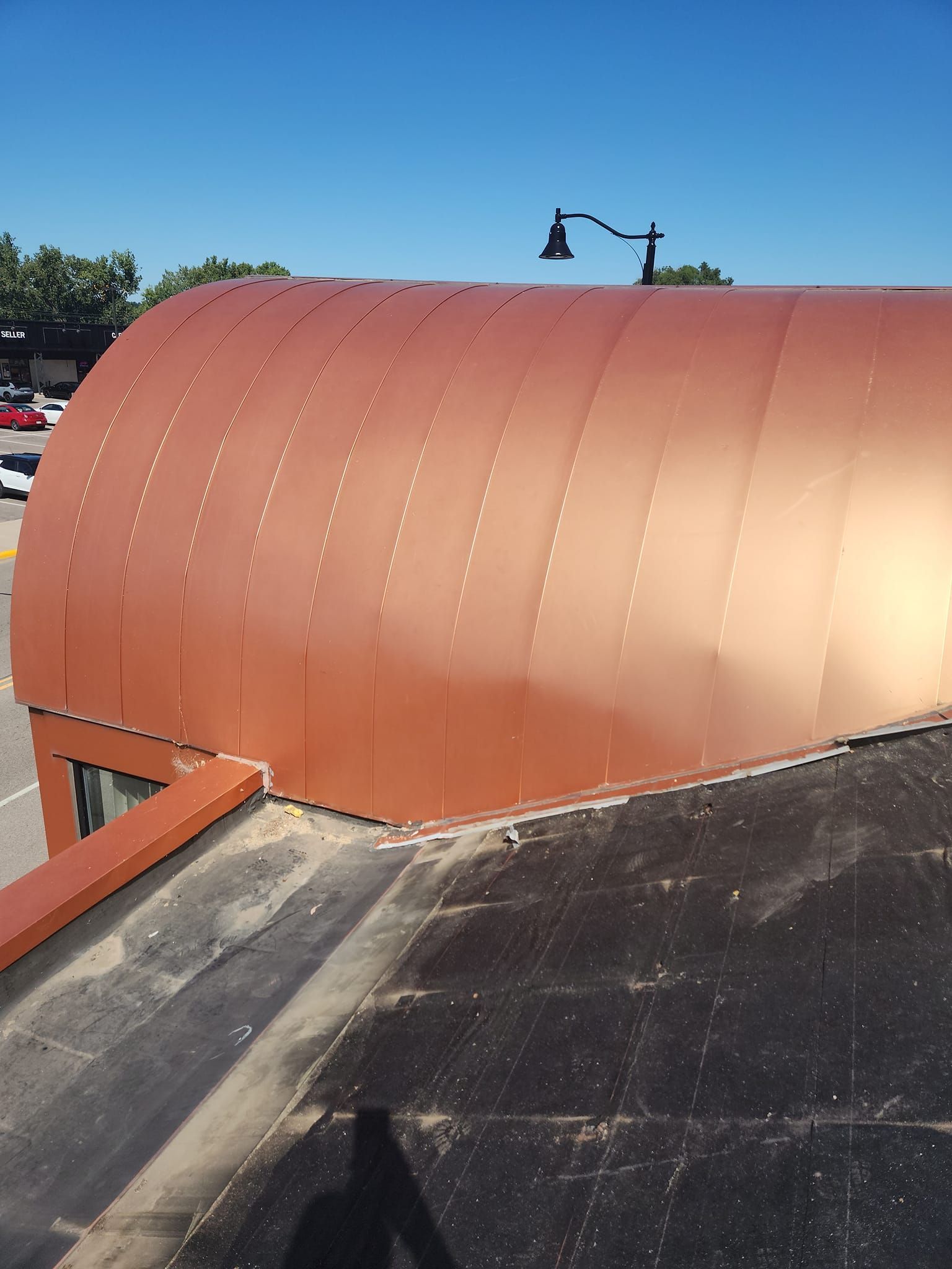 A copper roof with a street light on top of it