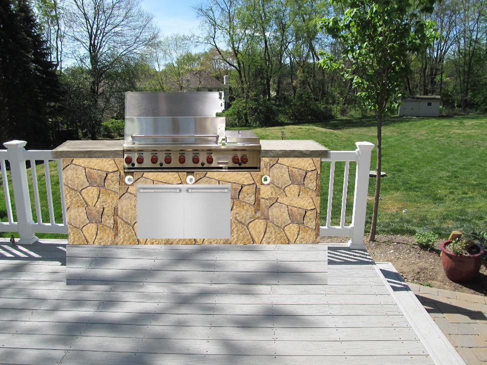 Outdoor stone grill built into a deck, with a stainless steel grill and storage.