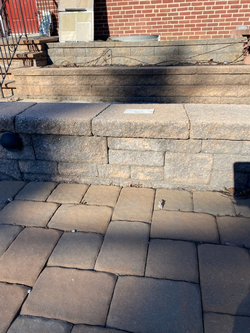 Stone steps and patio leading to a brick building, with a built-in planter.
