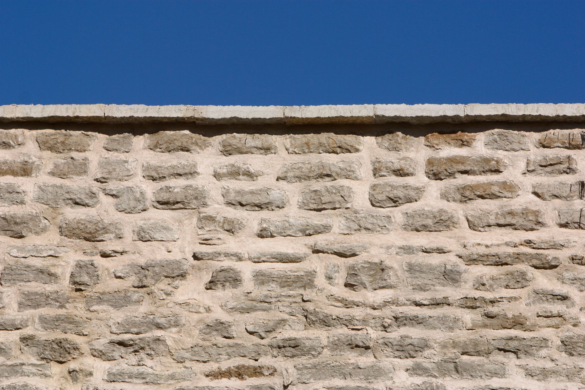 Stone wall against a clear blue sky.