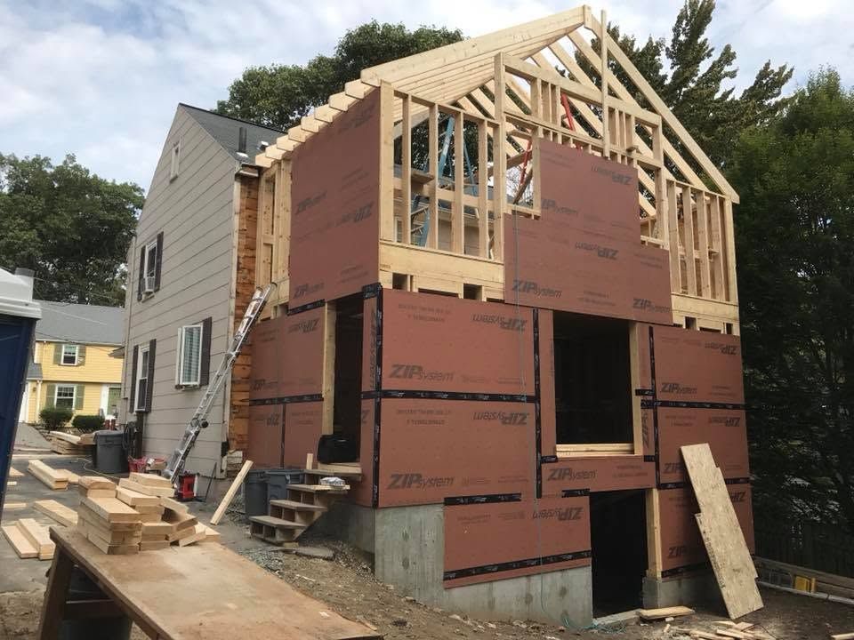 Partially built house with exposed framing and red insulation boards on a construction site