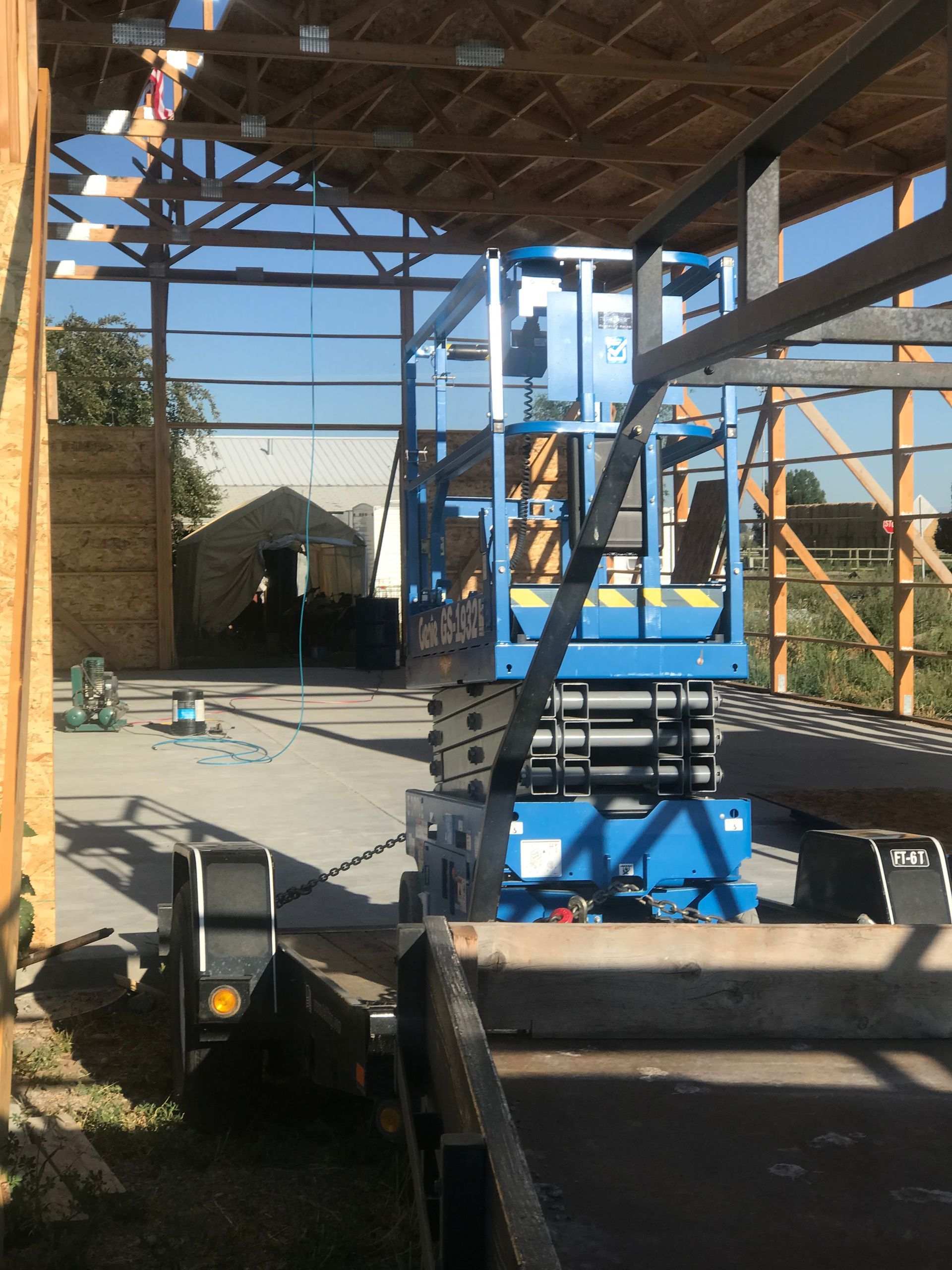 A blue scissor lift is sitting inside