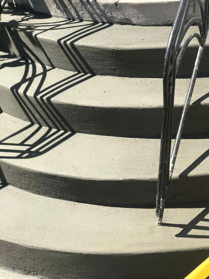 A close up of a set of concrete stairs with a metal railing