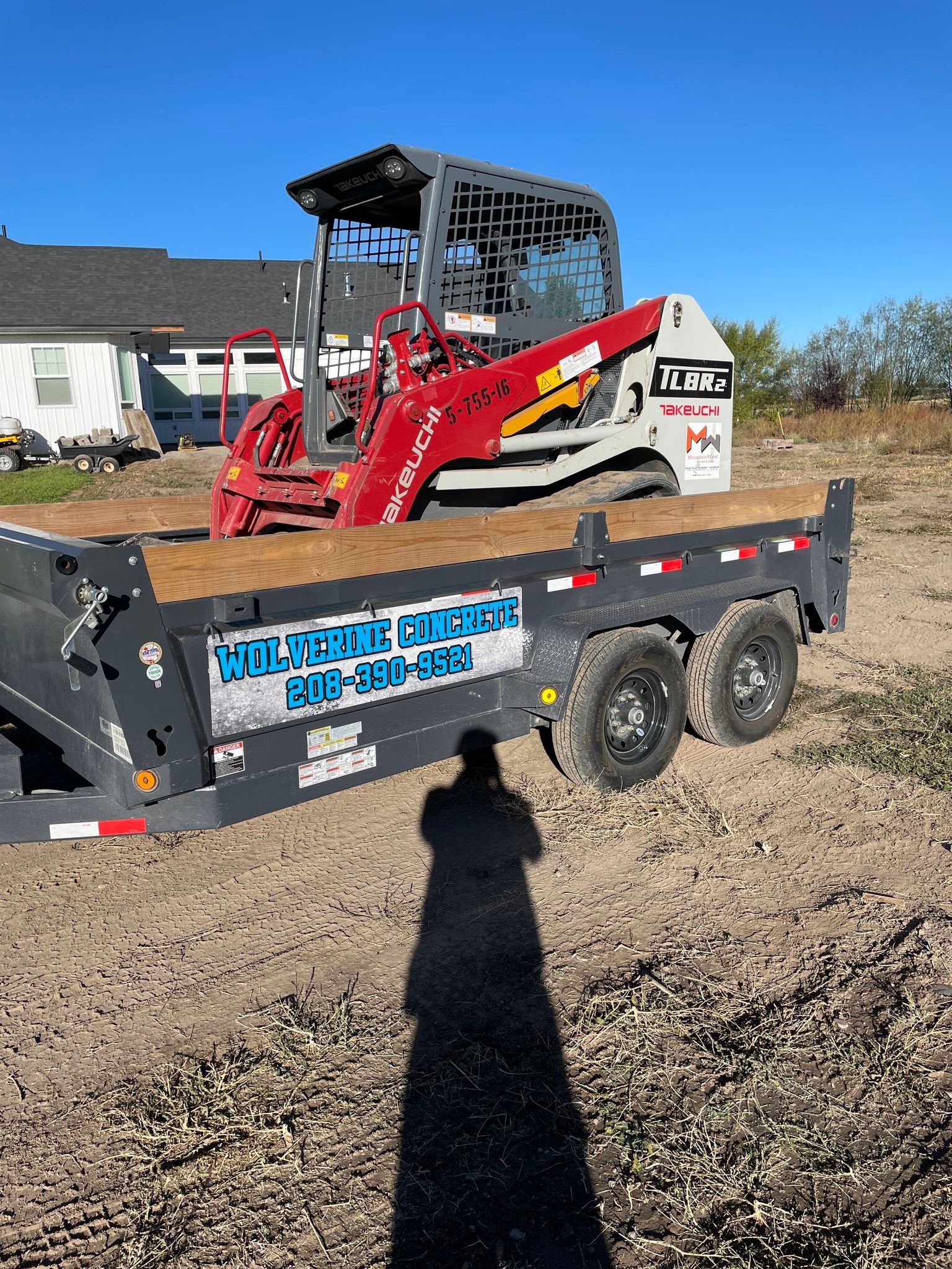 A bulldozer is parked on a trailer in a dirt field.