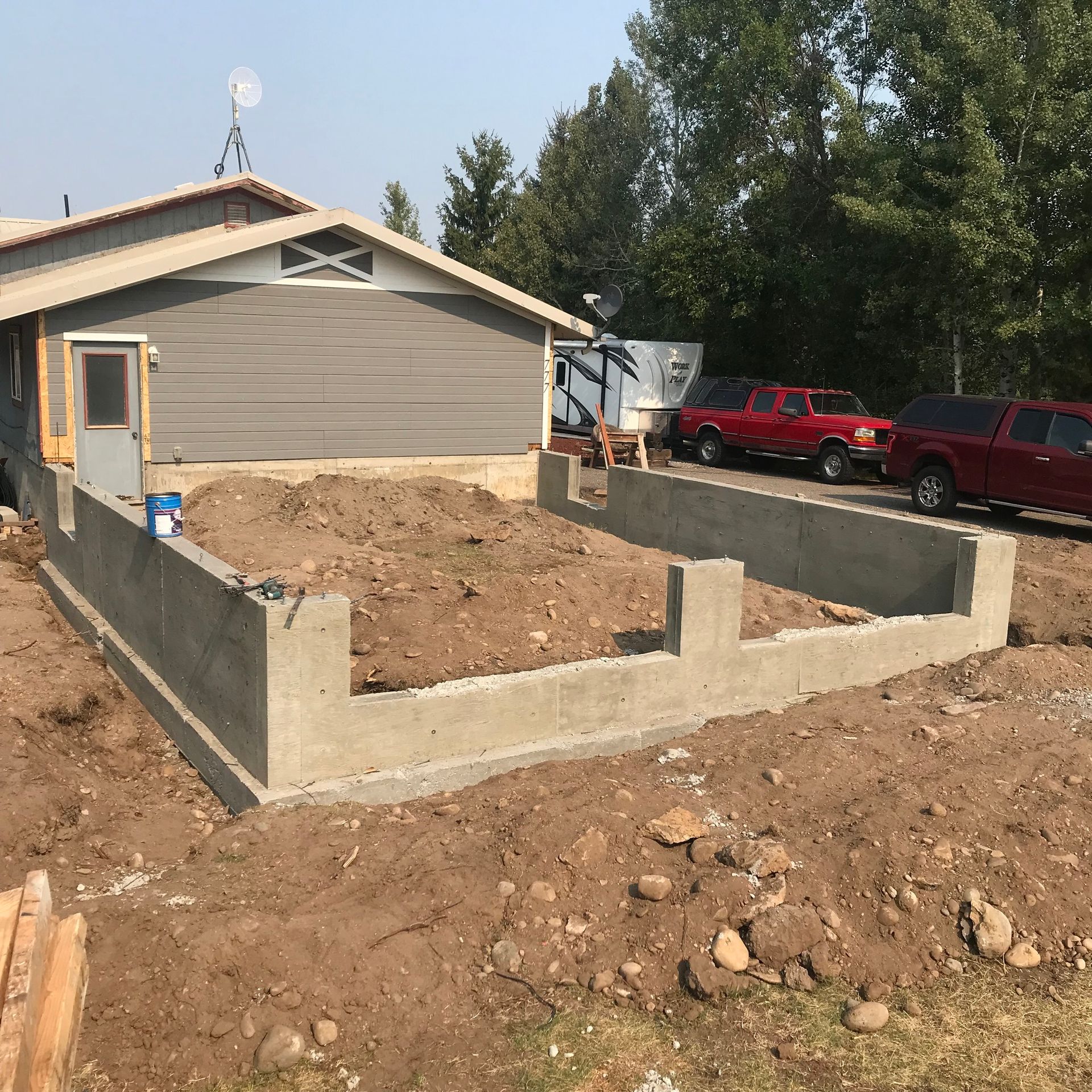 A concrete foundation is being built in front of a house