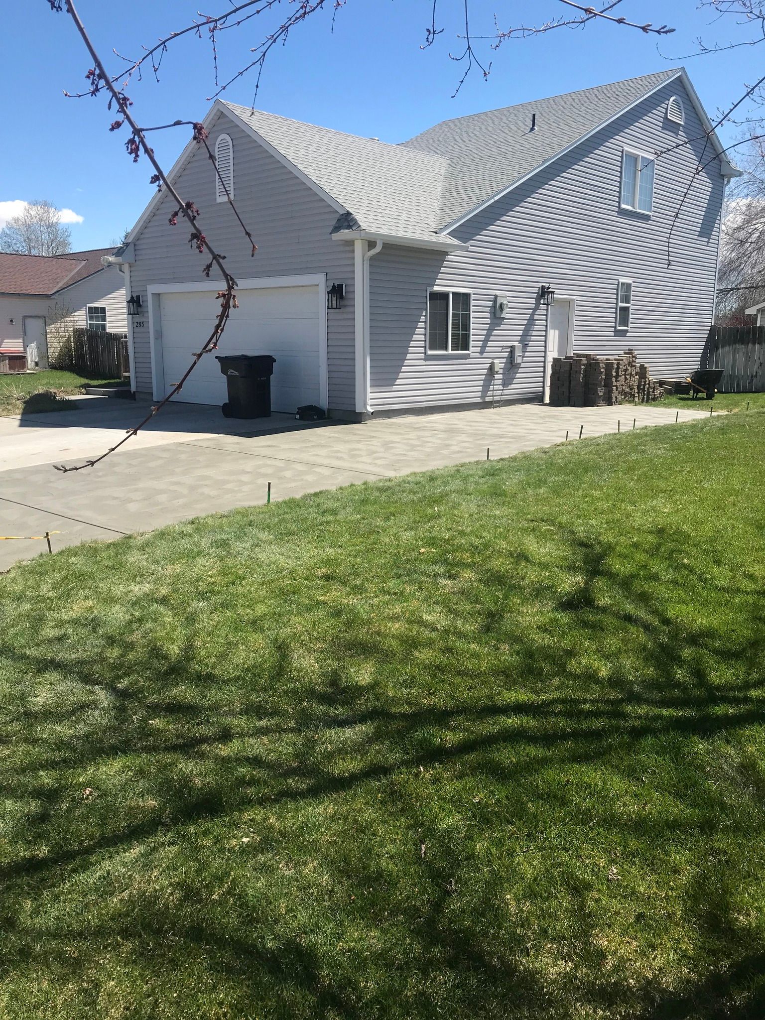 A house with a garage and a large lawn in front of it.