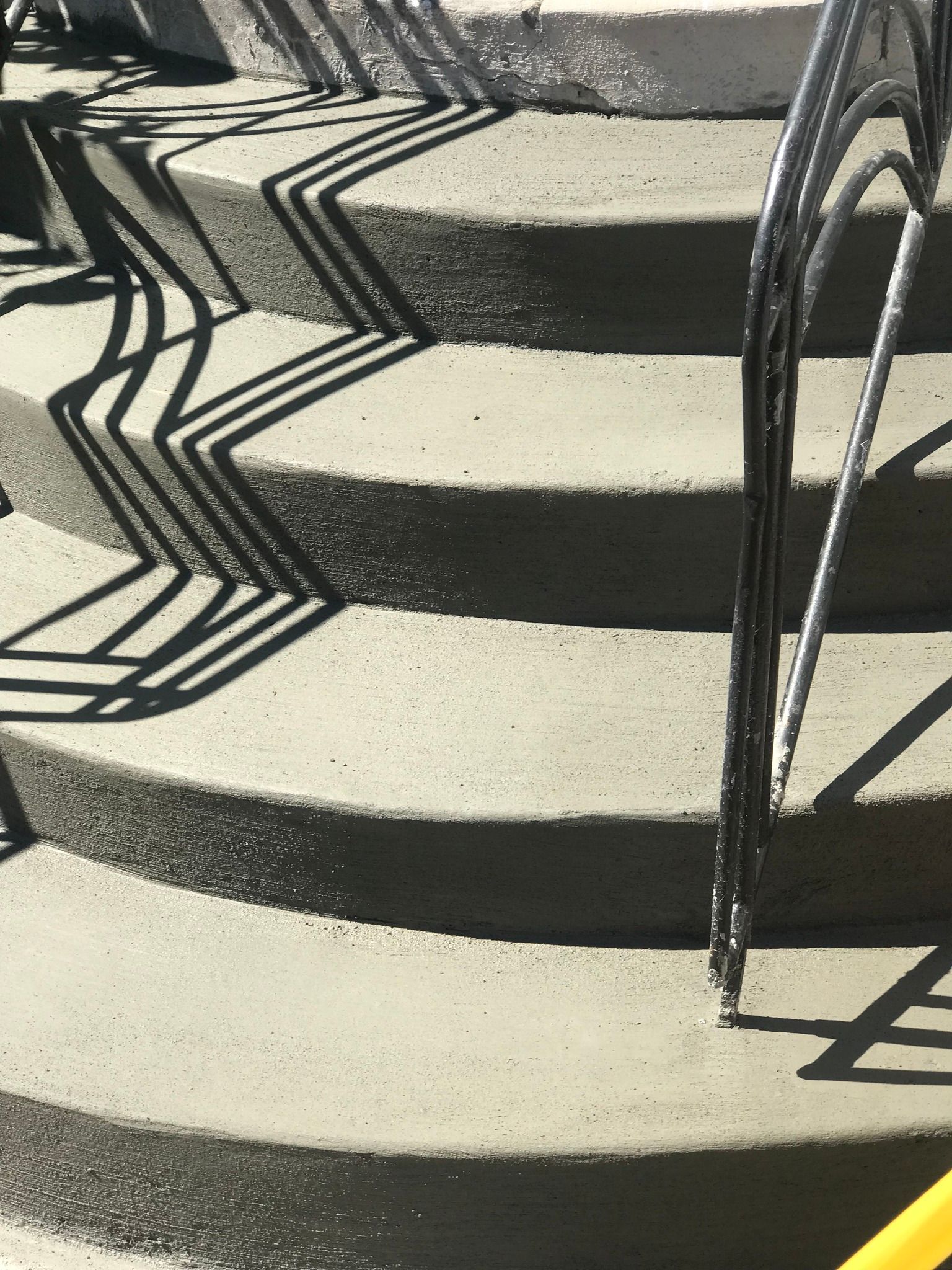 A close up of a set of concrete stairs with a metal railing.