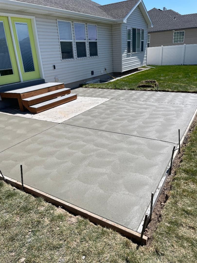 A concrete driveway is being built in front of a house.