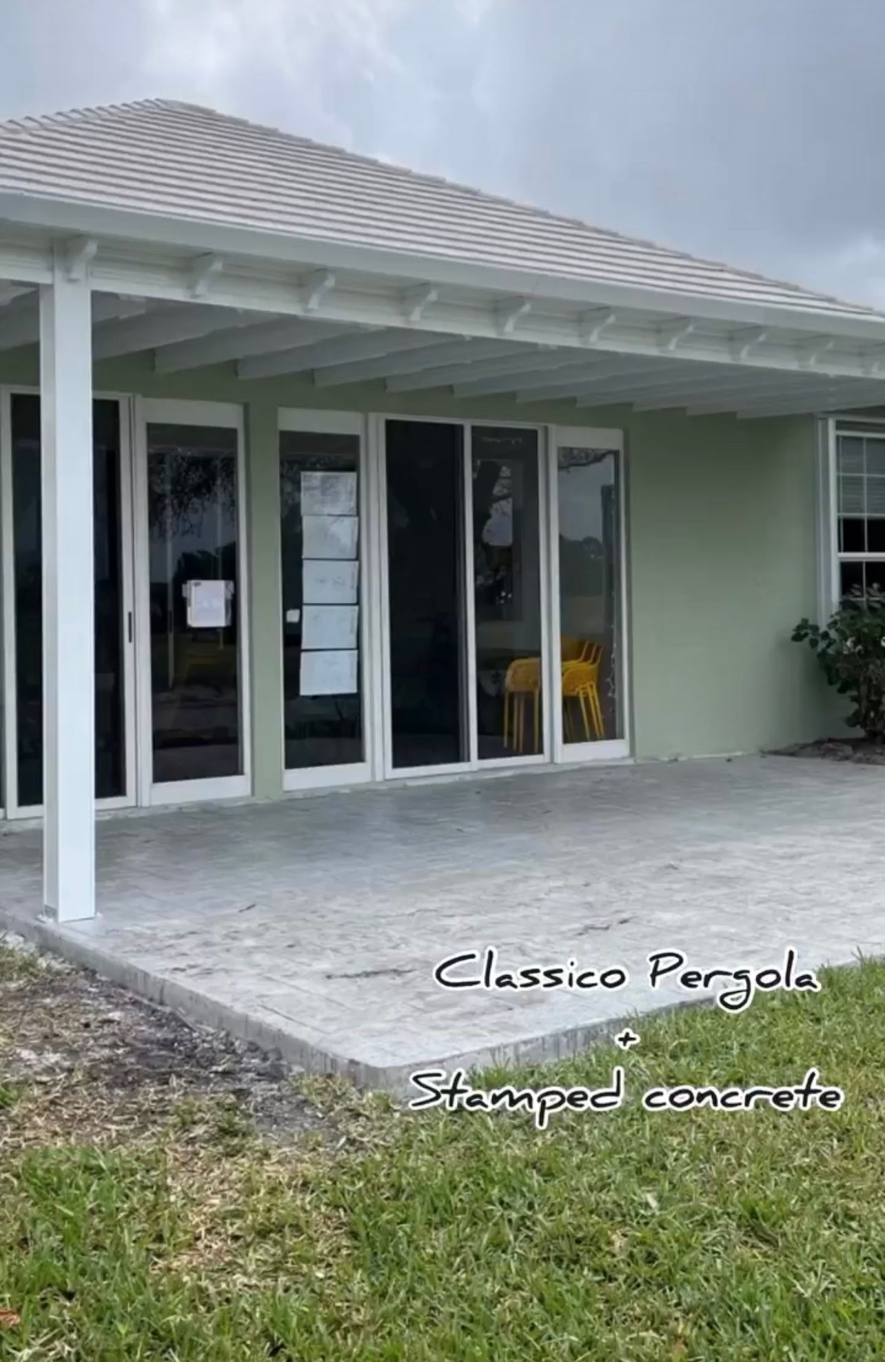A house with a covered patio and sliding glass doors.