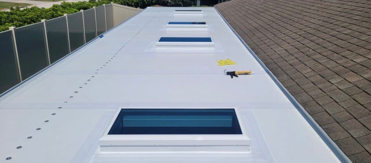 A white roof with a lot of skylights on it.