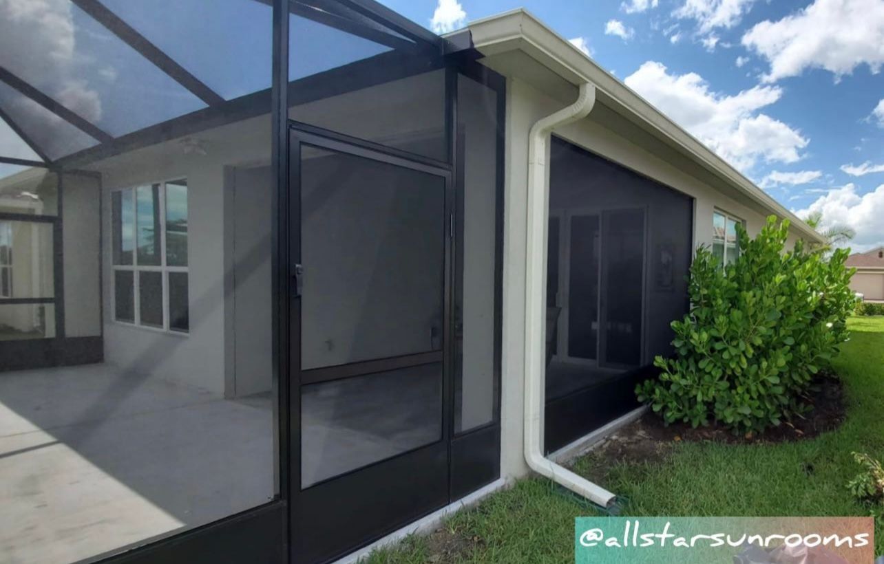A house with a screened in porch and a gutter.