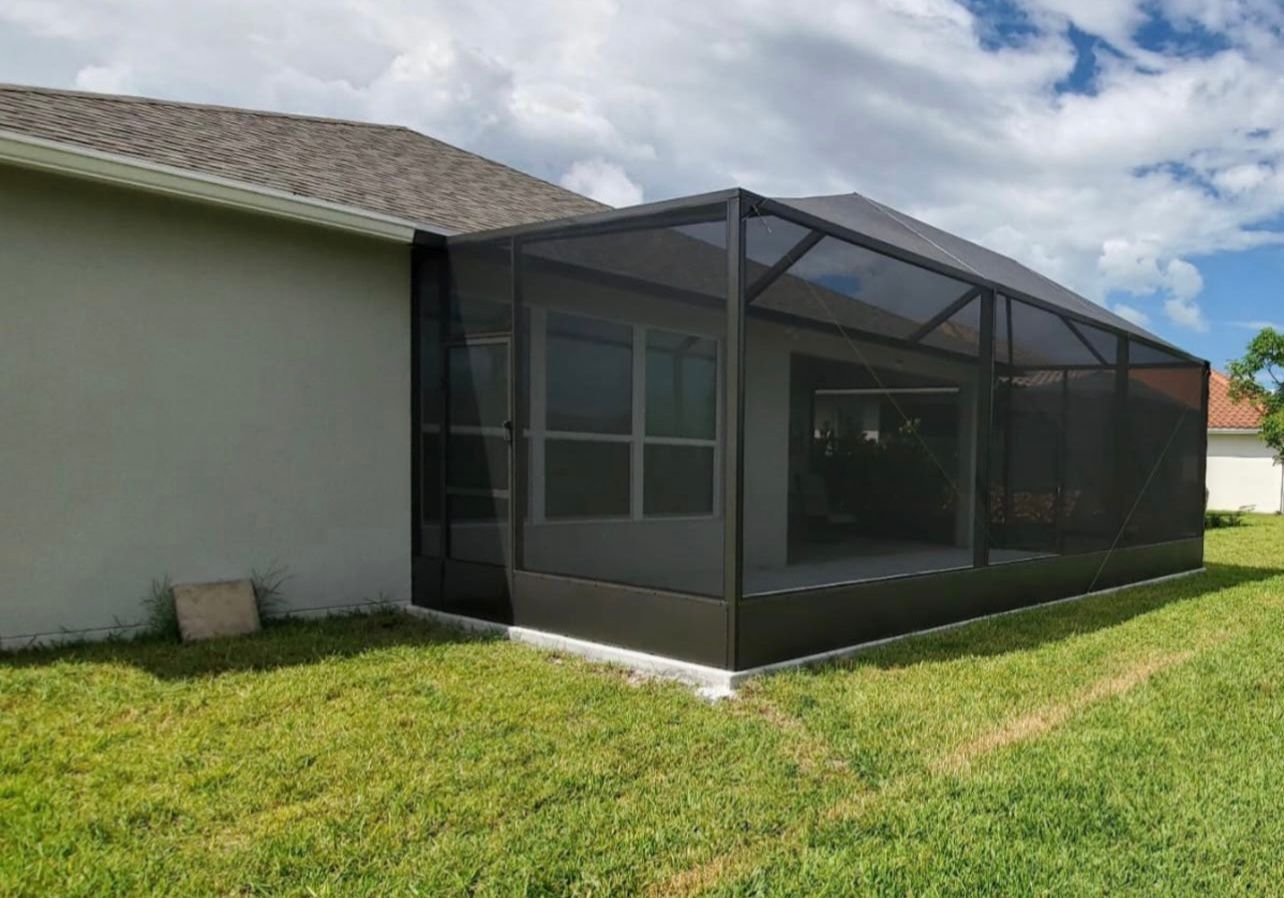 There is a screened in porch in the backyard of a house.