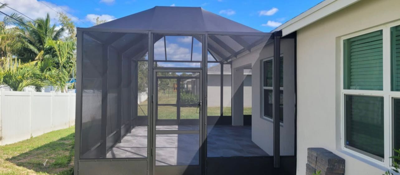 There is a screened in porch in the backyard of a house.